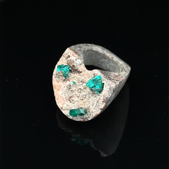 Der Steinring mit Dioptaskristallen auf Muttergestein ist ein einzigartiges Schmuckstück aus einem Naturstein geschliffen. Tragen Sie diesen Ring als auffälliges Statement-Piece zu schlichter Kleidung, um die intensiven Farben der Kristalle hervorzuheben. Ideal für besondere Anlässe und tägliche Eleganz. Perfekt als Geschenk oder persönliche Erweiterung Ihrer Schmucksammlung.