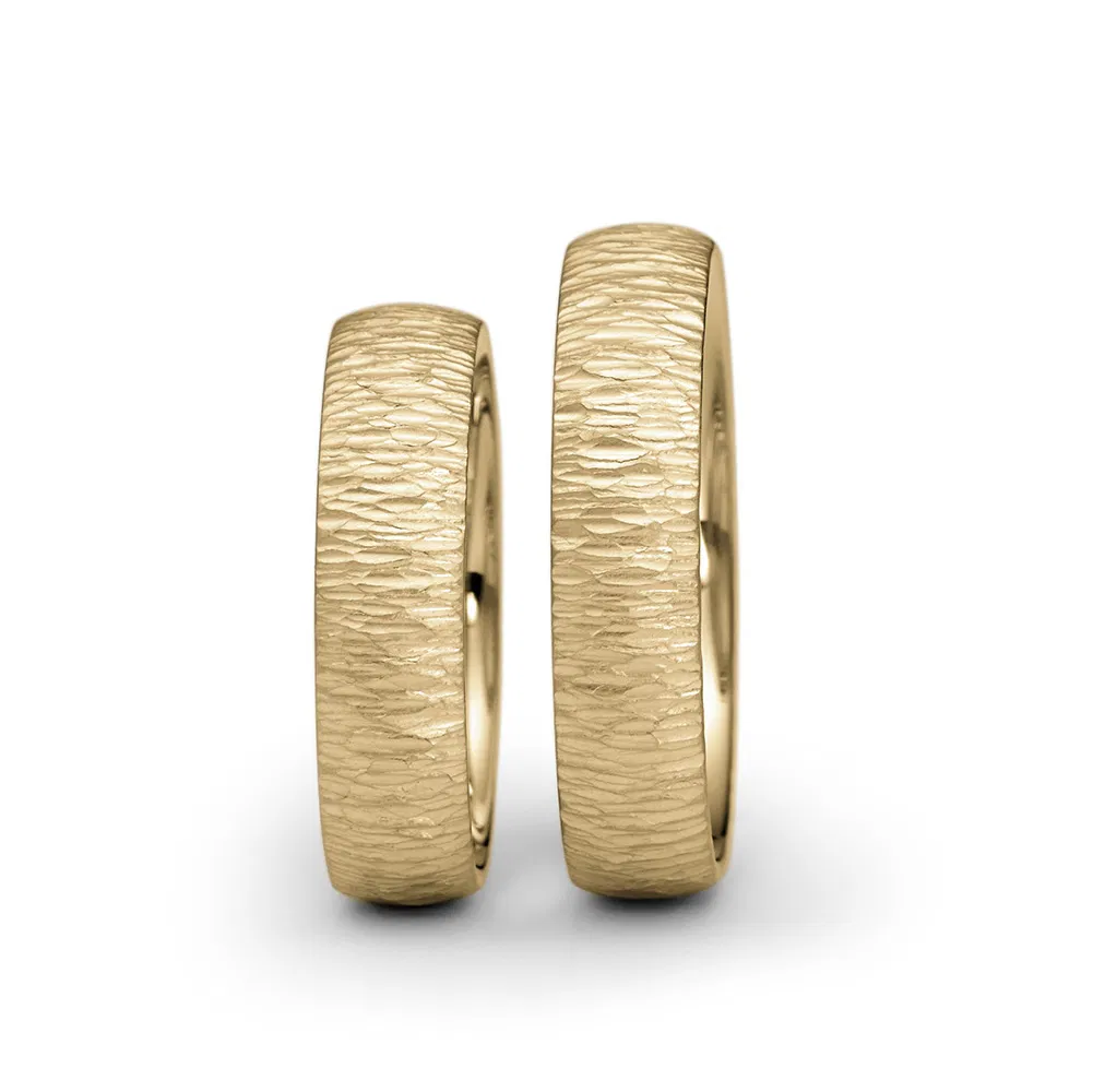 een 14  krt geelgouden ring van Niessing Linear met hammerslag bewerking.
ring is 7mm breed.