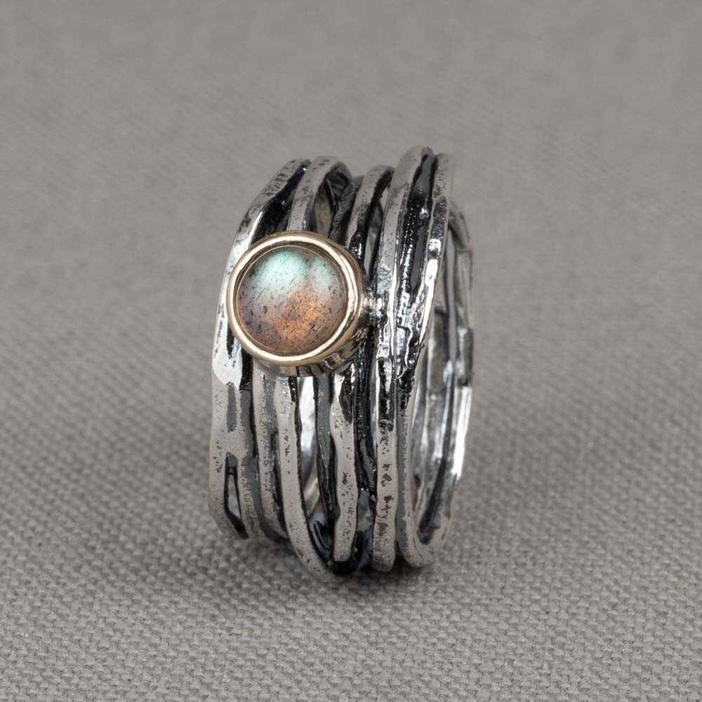 Ring gemaakt van 925 geoxideerd sterling zilver. De ring is met de hand gedraaid met bovenop in een kastje van 9 karaat een Labradoriet. Combineer met de andere sieraden van J&eacute;h Jewels voor een complete look!