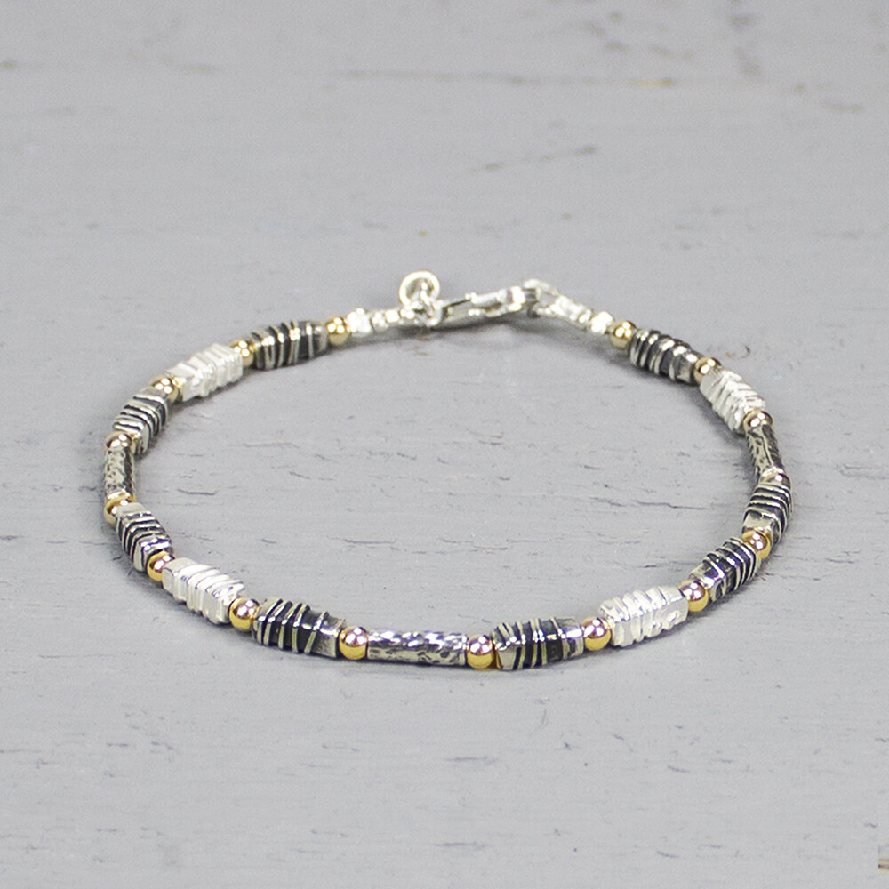 Armband uit de Touch of Gold-collectie van Jeh Jewels, gemaakt van 925 sterling zilver, geoxideerd zilver en gold filled. De schakels hebben allemaal een unieke stuctuur, wat deze armband zo bijzonder maakt. Combineer deze armband met het bijpassende collier. De glans van 925 sterling zilver maakt het een gewild edelmetaal voor de vervaardiging van sieraden. Het bestaat uit 92,5% puur zilver en 7,5% koper. Puur zilver is een zacht en buigzaam materiaal, het koper in 925 sterling zilver zorgt voor de stevigheid. De sieraden van Jeh Jewels zijn nikkel vrij. Gold filled komt uit Amerika en wordt daar al langer gebruikt voor de vervaardiging van sieraden met een "touch of gold" voor een betaalbare prijs. Het gold filled blijft op kleur, is slijtvast en de goudlaag is dik genoeg om lang te kunnen genieten van de warme uitstraling van goud. Gold filled wordt veelal ook goed verdragen door mensen die allergisch zijn voor andere metalen dan goud.