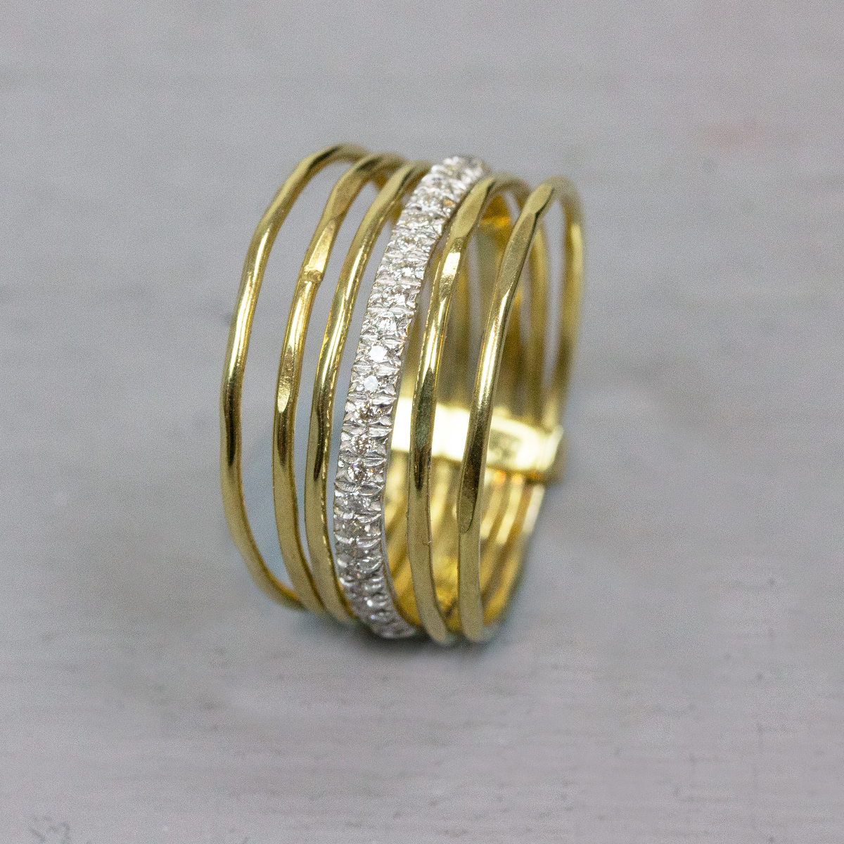Ring bestaande uit drie losse ringen, waarvan de middelste omhuld is met diamanten. 0.115ct