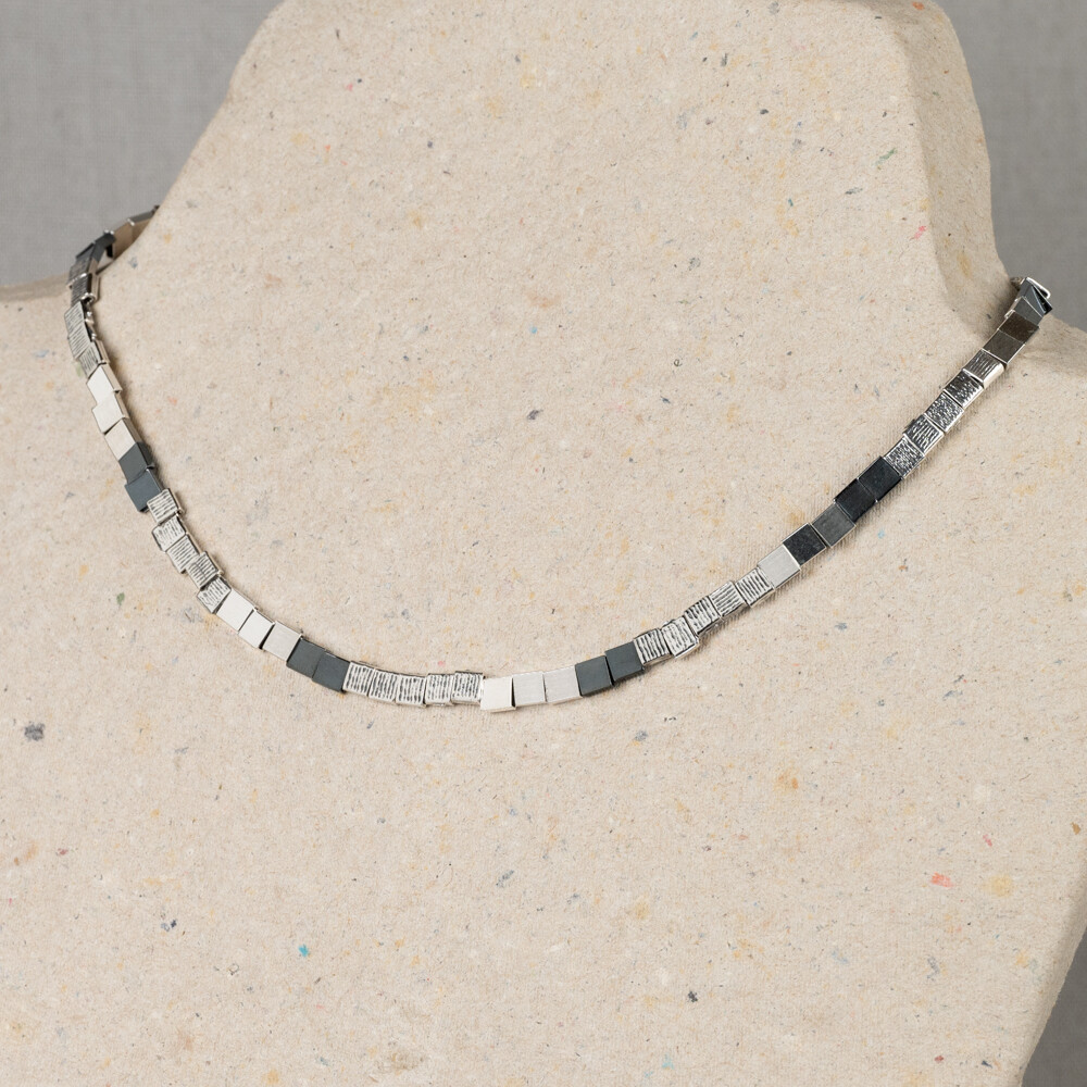 Collier uit de Silver-collectie van Jeh Jewels, gemaakt van 925 sterling zilver en geoxideerd zilver. Het collier bestaat uit vierkante blokjes met ieder een eigen structuur. Combineer dit collier met het bijpassende armband van Jéh Jewels.