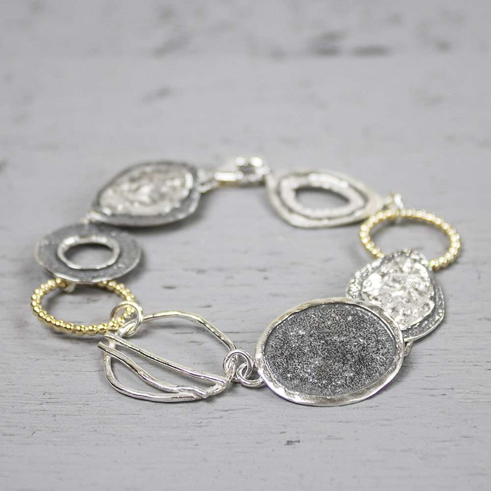 Armband gemaakt van 925 sterling zilver, geoxideerd zilver en Goldfilled. Deze armband bestaat uit verschillende organische vormen, wisselend van materiaal wat hem daardoor 3 kleuren geeft. Draag met het bijpassende collier voor een complete look!