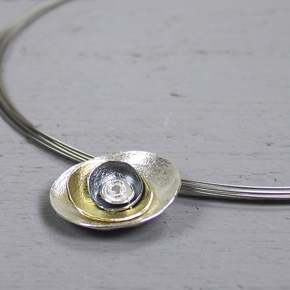 Hanger uit de Touch of Gold-collectie van Jeh Jewels, gemaakt van 925 sterling wit zilver, geoxideerd zilver en zilver verguld. De hanger bestaat uit 3 verschillende kleuren ronde lagen opgestapeld van groot naar klein. Combineer de hanger met de bijpassende oorstekers voor een complete set!