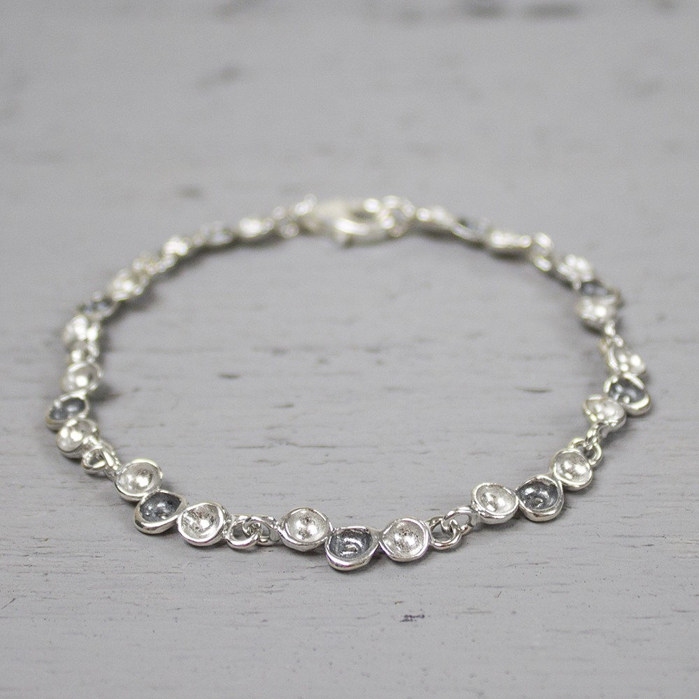 Deze armband is gemaakt van 925 sterling zilver en geoxideerd zilver. De armband bevat schakels bestaande uit drie druppels, waarvan de middelste geoxideerd is. Combineer met het bijpassende collier en de bijpassende oorbellen voor een complete look!