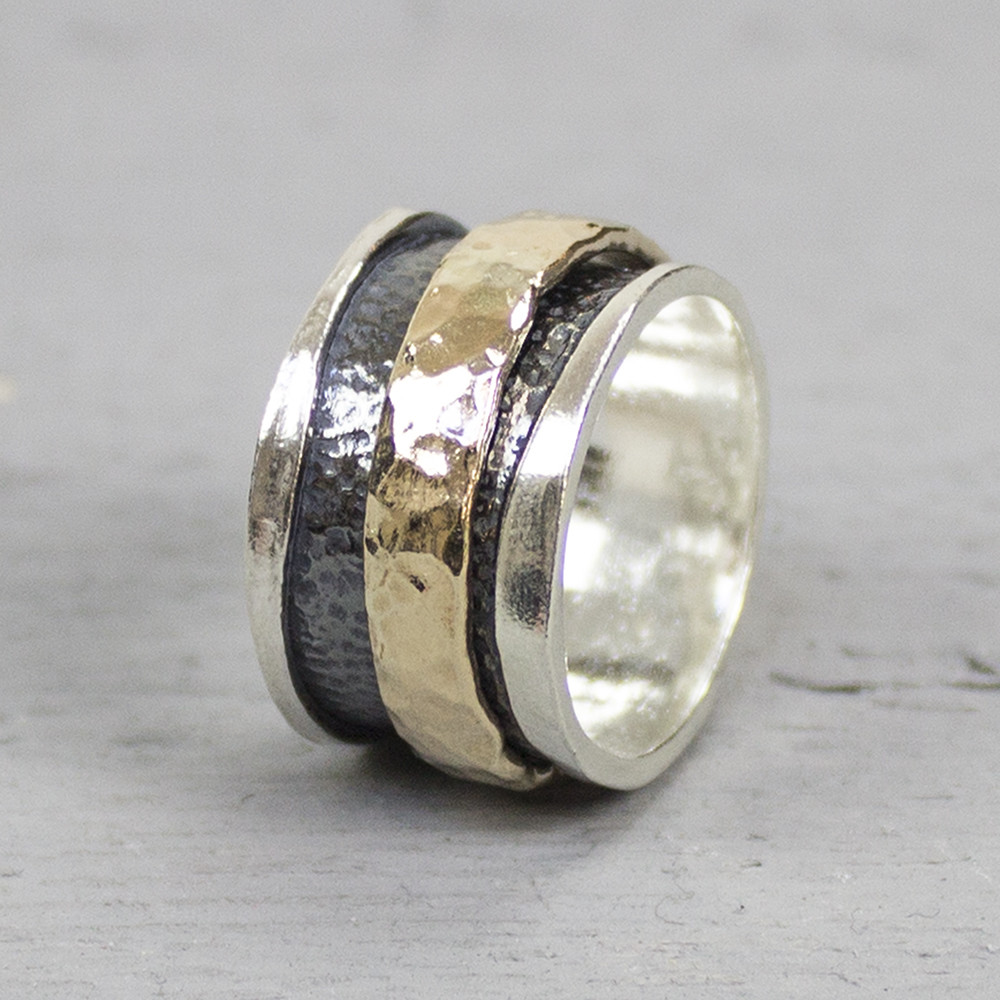 Deze ring is gemaakt van 925 sterling zilver, geoxideerd zilver en gold filled. De binnen ring is gemaakt van gold filled en is bewerkt met hamerslag. Deze ring kan speels heen en weer bewegen doordat hij genoeg ruimte heeft bij deze brede ring. De onderkant van de ring is geoxideerd en tevens bewerkt met hamerslag. De glans van 925 sterling zilver maakt het een gewild edelmetaal voor de vervaardiging van sieraden. Het bestaat uit 92,5% puur zilver en 7,5% koper. Puur zilver is een zacht en buigzaam materiaal, het koper in 925 sterling zilver zorgt voor de stevigheid. De sieraden van Jeh Jewels zijn nikkel vrij. Gold filled komt uit Amerika en wordt daar al langer gebruikt voor de vervaardiging van sieraden met een "touch of gold" voor een betaalbare prijs. Het gold filled blijft op kleur, is slijtvast en de 14karaats goudlaag is dik genoeg om lang te kunnen genieten van de warme uitstraling van goud. Gold filled wordt veelal ook goed verdragen door mensen die allergisch zijn voor andere metalen dan goud.