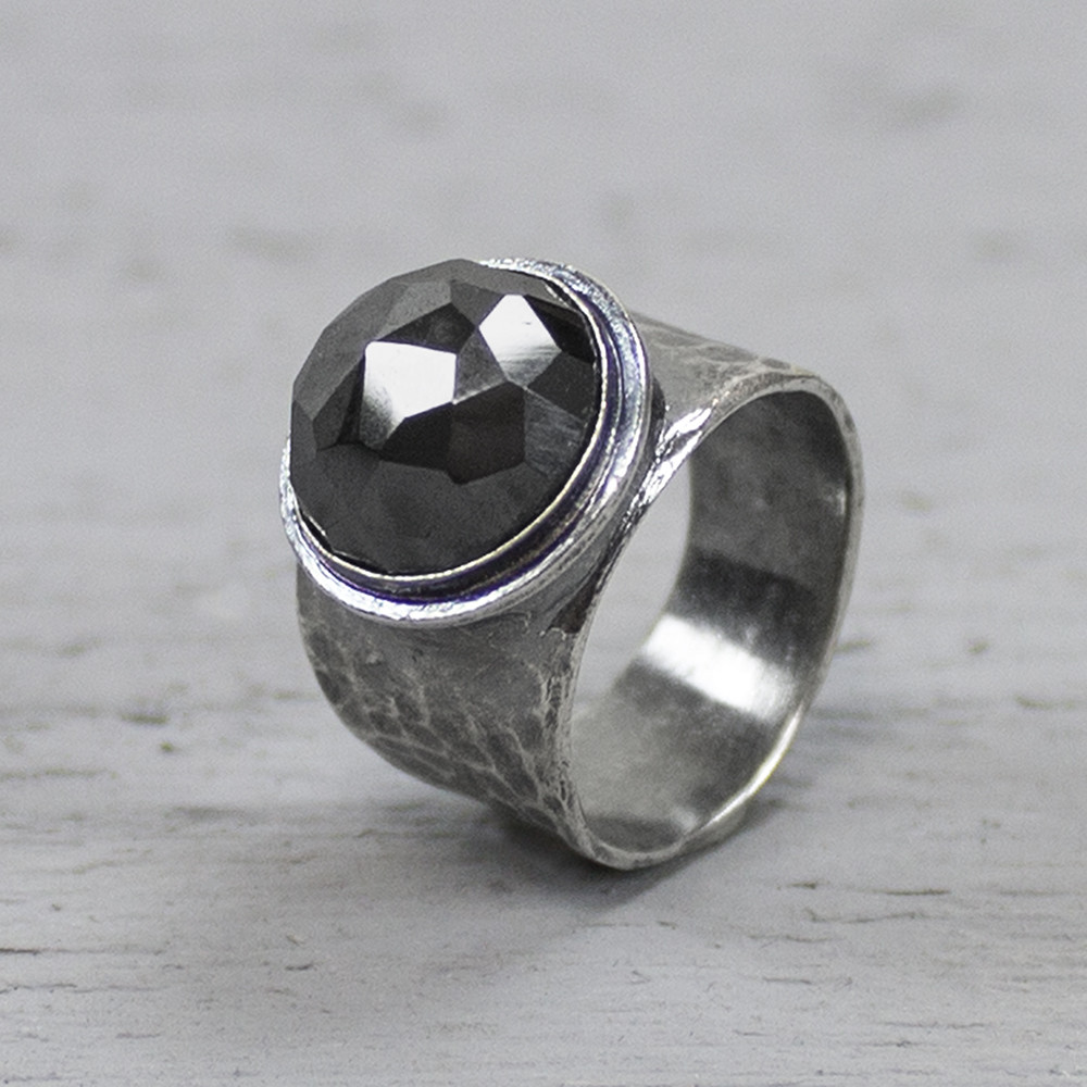 Ring uit de Silver-collectie van Jeh Jewels, gemaakt van 925 sterling zilver met gefacetteerde hematiet. De ring is bewerkt met hamerslag wat zorgt voor een mooie structuur. Hematiet werkt aardend, beschermend en harmoniserend. De steen geeft zelfvertrouwen, vergroot het zelfrespect en de overlevingsdrang en versterkt de wilskracht. Grootte steen: 1 cm De glans van 925 sterling zilver maakt het een gewild edelmetaal voor de vervaardiging van sieraden. Het bestaat uit 92,5% puur zilver en 7,5% koper. Puur zilver is een zacht en buigzaam materiaal, het koper in 925 sterling zilver zorgt voor de stevigheid. De sieraden van Jeh Jewels zijn nikkel vrij. Bij Jeh Jewels werken wij met echte edelstenen, dit zijn natuurlijke producten waardoor niet iedere steen hetzelfde is. Iedere ring is hierbij dus uniek. De kleur en structuur van de steen kan afwijken van de foto op de website.