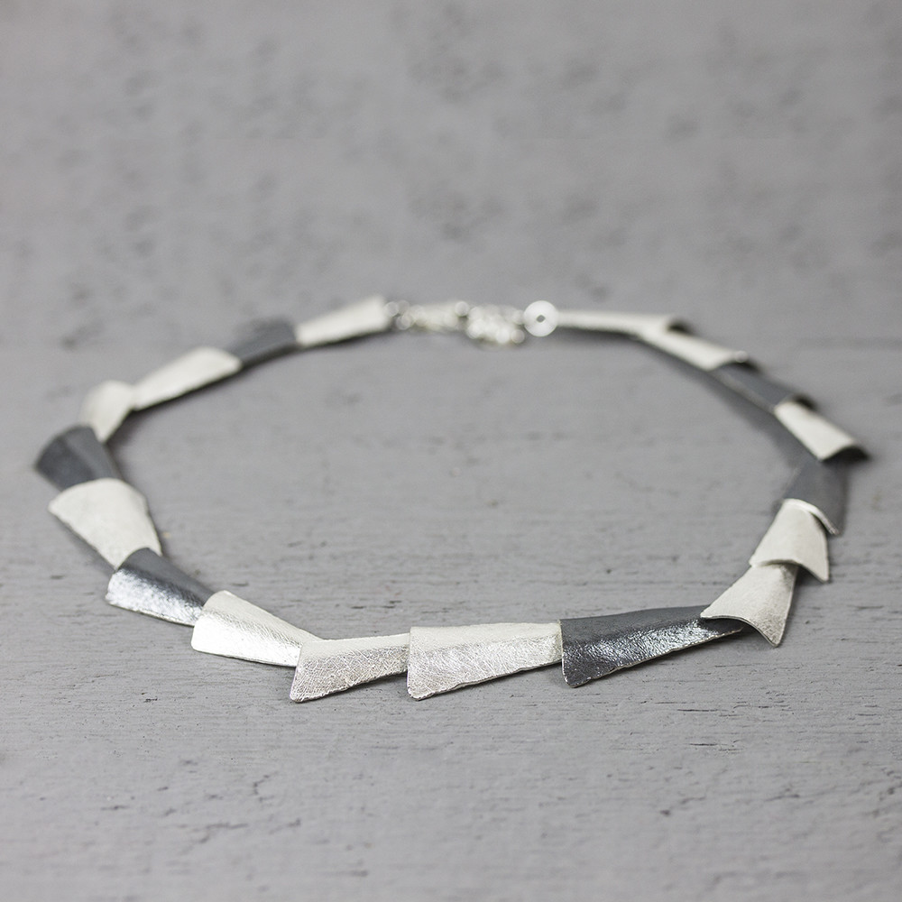 Collier met driehoekige schakels, gemaakt van 925 sterling zilver en geoxideerd zilver.