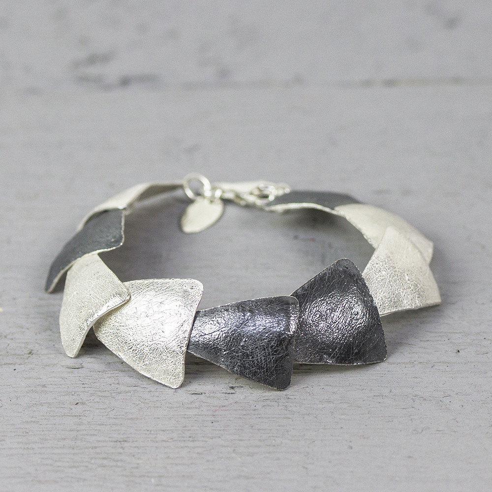Armband driehoekig, gemaakt van 925 sterling wit zilver en geoxideerd zilver. De glans van 925 sterling zilver maakt het een gewild edelmetaal voor de vervaardiging van sieraden. Het bestaat uit 92,5% puur zilver en 7,5% koper. Puur zilver is een zacht en buigzaam materiaal, het koper in 925 sterling zilver zorgt voor de stevigheid. De sieraden van Jeh Jewels zijn nikkel vrij.