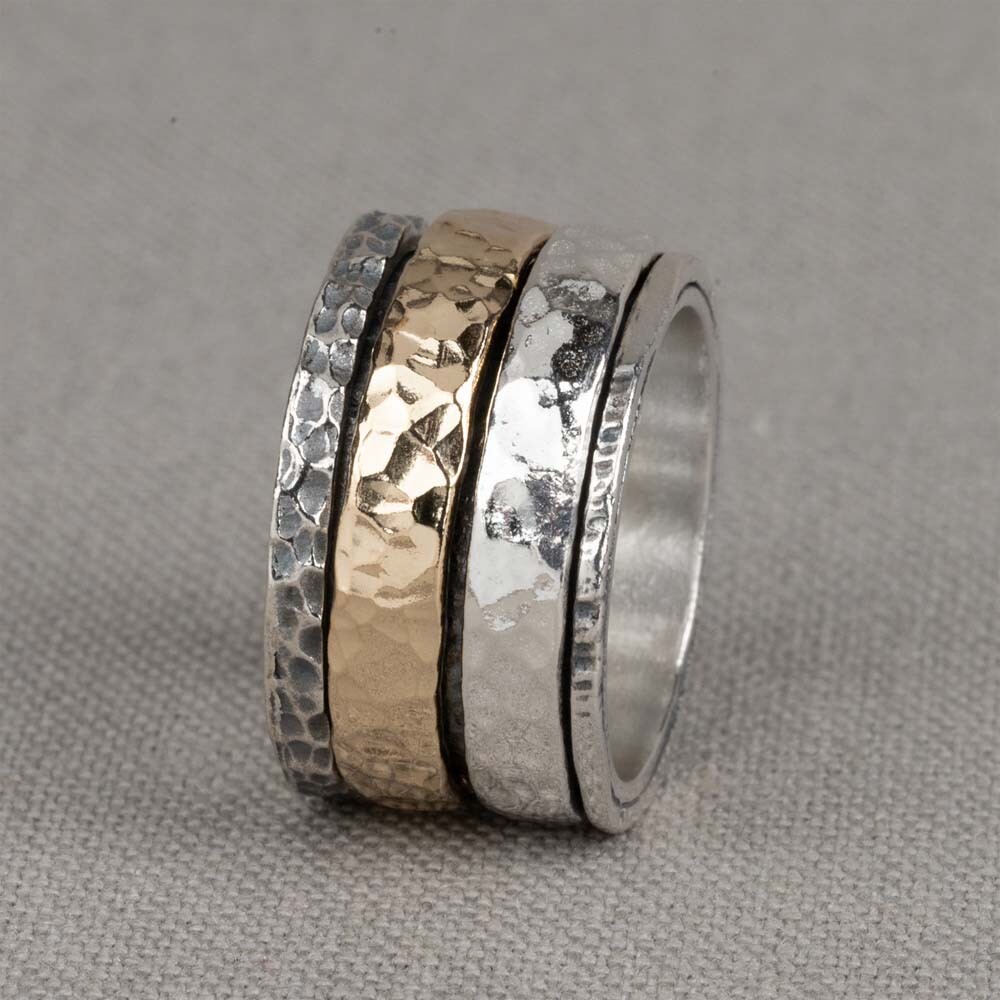 Ring gemaakt van 925 sterling zilver, geoxideerd zilver en goldfilled. Om de basis ring zitten twee brede banden, waarvan één van zilver en de ander van goldfilled.