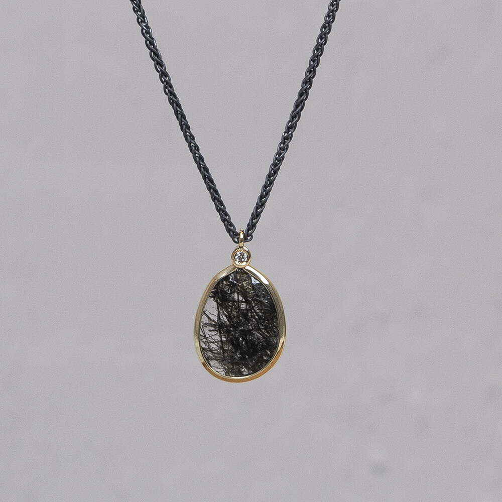 Collier gemaakt van 925 sterling zilver en G14K, in de hanger zit een steen van Black Rutielkwarts. De glans van 925 sterling zilver maakt het een gewild edelmetaal voor de vervaardiging van sieraden. Het bestaat uit 92,5% puur zilver en 7,5% koper. Puur zilver is een zacht en buigzaam materiaal, het koper in 925 sterling zilver zorgt voor de stevigheid. De sieraden van Jeh Jewels zijn nikkel vrij. De gouden sieradenlijn van Jéh is gemaakt van 14 karaats goud. Dit karaatgehalte wordt in Nederland het meest gebruikt, vanwege de hardheid en de kleur. Puur goud is te zacht om draagbare sieraden van te maken, daarom worden er bij metalen gebruikt. Vaak wordt er zilver en koper gebruikt zodat je kunt blijven spreken van 'edele metalen'. Bij 14 karaat goud zijn er van de 1000 delen, 585 delen puur goud. De overige 415 delen bestaan dus uit de overige metalen.