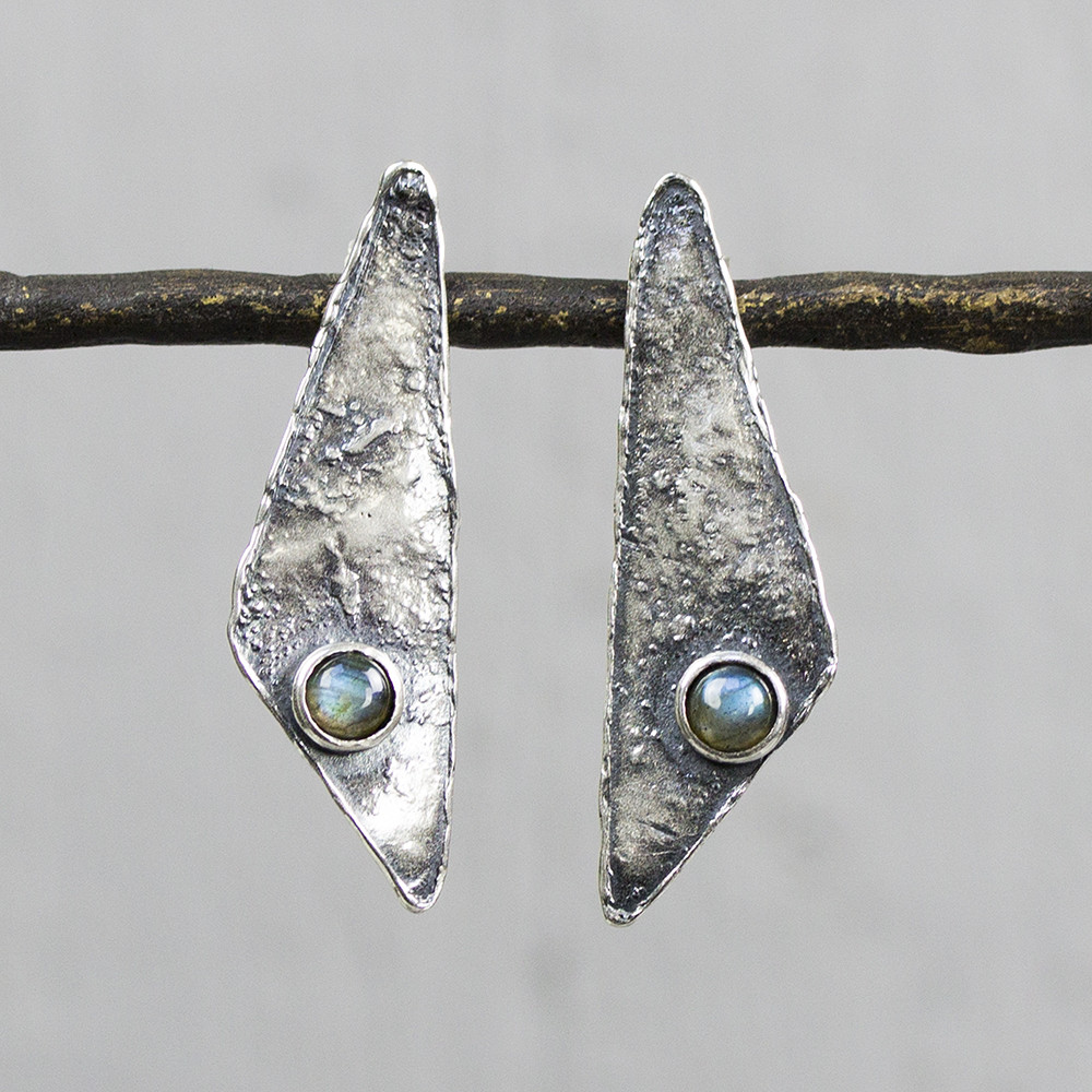 Oorsteker gemaakt van 925 sterling zilver met geoxideerd zilver. De oorbel heeft een driehoekige vorm, met op beide onderin een Labradoriet. Labradoriet is een sterk beschermende en spirituele steen. Het beschermt het eigen energieveld (aura) tegen negatieve invloeden uit de omgeving. Op dit sieraad is gebruik gemaakt van geoxideerd zilver, dit is een oppervlakte bewerking. Het is mogelijk dat de geoxideerde laag na verloop van tijd door slijtage vervaagd. De glans van 925 sterling zilver maakt het een gewild edelmetaal voor de vervaardiging van sieraden. Het bestaat uit 92,5% puur zilver en 7,5% koper. Puur zilver is een zacht en buigzaam materiaal, het koper in 925 sterling zilver zorgt voor de stevigheid. De sieraden van Jeh Jewels zijn nikkel vrij. Bij Jéh Jewels werken wij met echte edelstenen, dit zijn natuurlijke producten waardoor niet iedere steen hetzelfde is. Ieder sieraad is hierbij dus uniek. De kleur en structuur van de steen kan afwijken van de foto op de website.