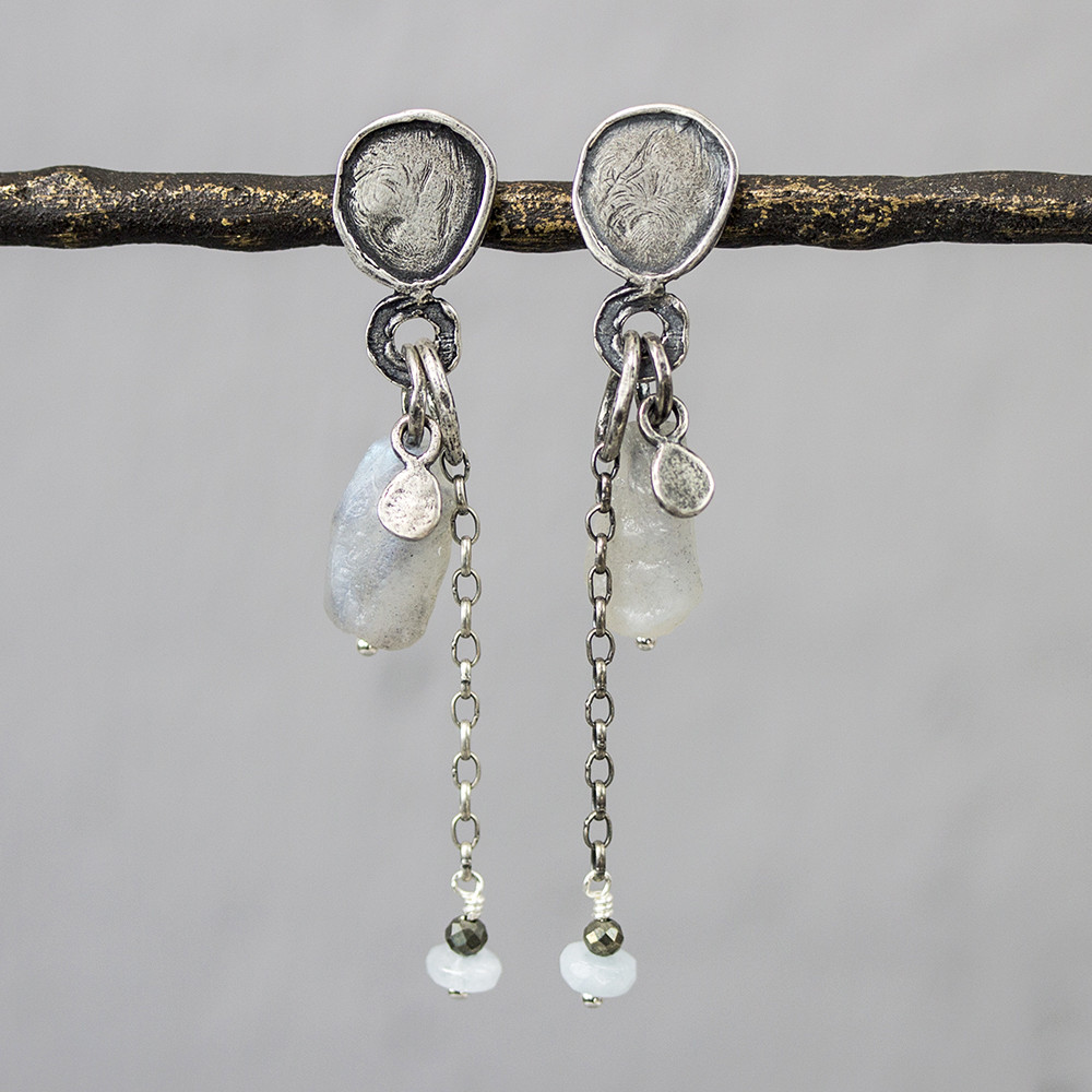 Oorsteker gemaakt van 925 geoxideerd sterling zilver, met aan de oorbel verschillende edelstenen. Van boven naar beneden is dat: Labradoriet, Pyriet en aquamarijn.