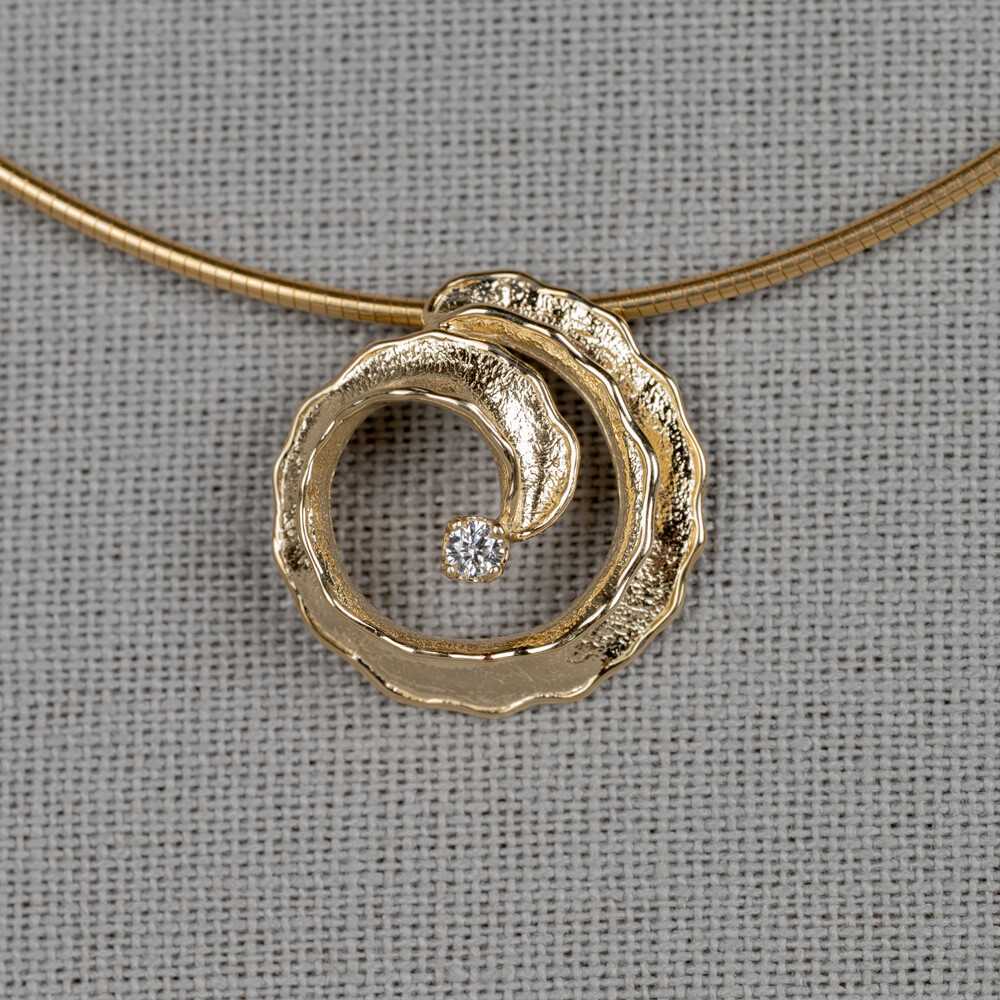 Hanger spiraal gemaakt van 14 karaat goud met daarin een diamant van 0.084CT I1/HI. Combineer deze hanger met de andere gouden sieraden uit de Curly-lijn.