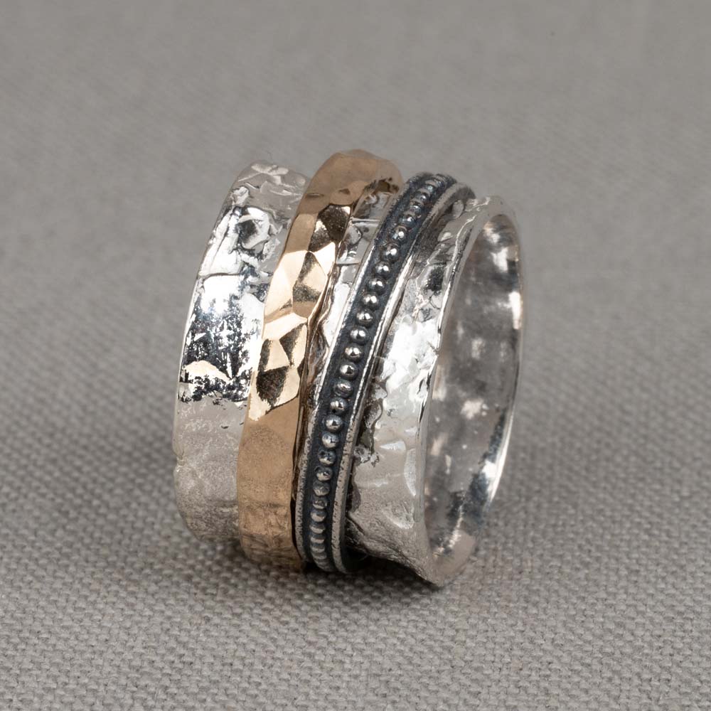 Stoere ring gemaakt van (geoxideerd) 925 sterling zilver en goldfilled. De ringen in het midden van de ring kunnen bewegen, dit zorgt voor een speels effect. De glans van 925 sterling zilver maakt het een gewild edelmetaal voor de vervaardiging van sieraden. Het bestaat uit 92,5% puur zilver en 7,5% koper. Puur zilver is een zacht en buigzaam materiaal, het koper in 925 sterling zilver zorgt voor de stevigheid. De sieraden van Jeh Jewels zijn nikkel vrij. Op dit sieraad is gebruik gemaakt van geoxideerd zilver, dit is een oppervlakte bewerking. Het is mogelijk dat de geoxideerde laag na verloop van tijd door slijtage vervaagd. Gold filled komt uit Amerika en wordt daar al langer gebruikt voor de vervaardiging van sieraden met een "touch of gold" voor een betaalbare prijs. Het gold filled blijft op kleur, is slijtvast en de goudlaag is dik genoeg om lang te kunnen genieten van de warme uitstraling van goud. Gold filled wordt veelal ook goed verdragen door mensen die allergisch zijn voor andere metalen dan goud.