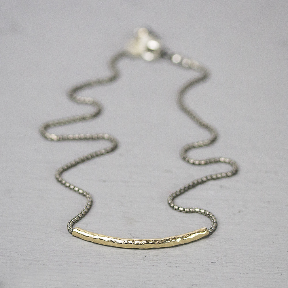 Collier gemaakt van 925 sterling geoxideerd zilver met daaraan een rond lopende buis van goldfilled.