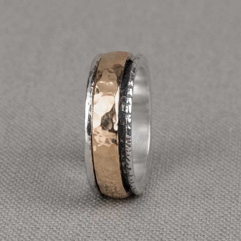 Brede zilveren ring met een losse goldfilled ring eromheen.