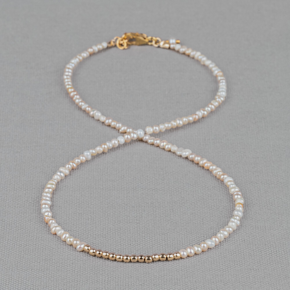 Collier gemaakt van offwhite roze parels met in het midden een rij Goldfilled bolletjes. Bij Jeh Jewels werken wij met echte edelstenen, dit zijn natuurlijke producten waardoor niet iedere steen hetzelfde is. Ieder sieraad is hierbij dus uniek. De kleur en structuur van de steen kan afwijken van de foto op de website.