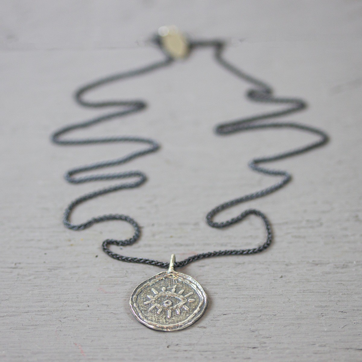 Collier gemaakt van 925 sterling geoxideerd sterling zilver, aan het collier hangt een zilvere hanger met daarop een creatief oog. De glans van 925 sterling zilver maakt het een gewild edelmetaal voor de vervaardiging van sieraden. Het bestaat uit 92,5% puur zilver en 7,5% koper. Puur zilver is een zacht en buigzaam materiaal, het koper in 925 sterling zilver zorgt voor de stevigheid. De sieraden van Jeh Jewels zijn nikkel vrij. Op dit sieraad is gebruik gemaakt van geoxideerd zilver, dit is een oppervlakte bewerking. Het is mogelijk dat de geoxideerde laag na verloop van tijd door slijtage vervaagd.