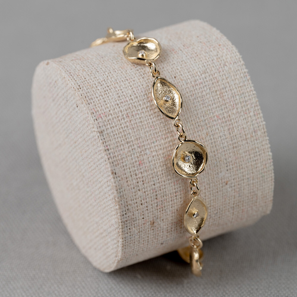Armband gemaakt van 14 karaat goud afwisseld met navet en ronde vormen, in de schakels zitten diamantjes van 0,165CT I1/HI