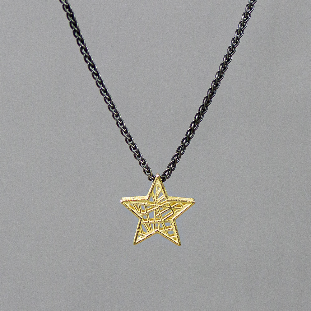 Collier gemaakt van 925 geoxideerd sterling zilver met daaraan een 3D ster van 14 karaat goud. De glans van 925 sterling zilver maakt het een gewild edelmetaal voor de vervaardiging van sieraden. Het bestaat uit 92,5% puur zilver en 7,5% koper. Puur zilver is een zacht en buigzaam materiaal, het koper in 925 sterling zilver zorgt voor de stevigheid. De sieraden van Jeh Jewels zijn nikkel vrij. Op dit sieraad is gebruik gemaakt van geoxideerd zilver, dit is een oppervlakte bewerking. Het is mogelijk dat de geoxideerde laag na verloop van tijd door slijtage vervaagd. De gouden sieradenlijn van Jéh is gemaakt van 14 karaats goud. Dit karaatgehalte wordt in Nederland het meest gebruikt, vanwege de hardheid en de kleur. Puur goud is te zacht om draagbare sieraden van te maken, daarom worden er bij metalen gebruikt. Vaak wordt er zilver en koper gebruikt zodat je kunt blijven spreken van 'edele metalen'. Bij 14 karaat goud zijn er van de 1000 delen, 585 delen puur goud. De overige 415 delen bestaan dus uit de overige metalen.