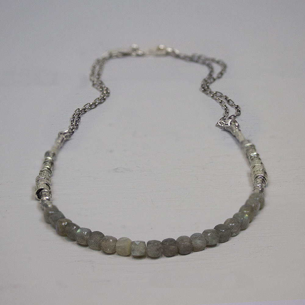 Collier gemaakt van 925 geoxideerd sterling zilver, tussen de zilveren delen zitten stukjes labradoriet. Labradoriet is een sterk beschermende en spirituele steen. Het beschermt het eigen energieveld (aura) tegen negatieve invloeden uit de omgeving. Lengte: 42 cm De glans van 925 sterling zilver maakt het een gewild edelmetaal voor de vervaardiging van sieraden. Het bestaat uit 92,5% puur zilver en 7,5% koper. Puur zilver is een zacht en buigzaam materiaal, het koper in 925 sterling zilver zorgt voor de stevigheid. De sieraden van Jeh Jewels zijn nikkel vrij. Op dit sieraad is gebruik gemaakt van geoxideerd zilver, dit is een oppervlakte bewerking. Het is mogelijk dat de geoxideerde laag na verloop van tijd door slijtage zal vervagen. Bij Jéh Jewels werken wij met echte edelstenen, dit zijn natuurlijke producten waardoor niet iedere steen hetzelfde is. Ieder sieraad is hierbij dus uniek. De kleur en structuur van de steen kan afwijken van de foto op de website.