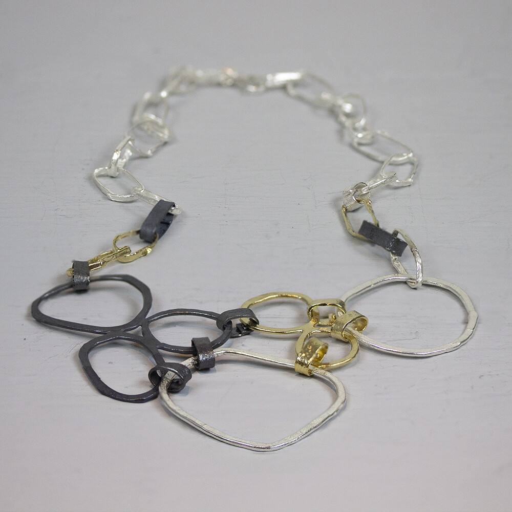 Collier gemaakt van 925 sterling zilver in combinatie met geoxideerd zilver en zilver verguld. Dit collier bestaat uit meerdere grote open schakels in de bekende drie Jeh Jewels kleuren.
