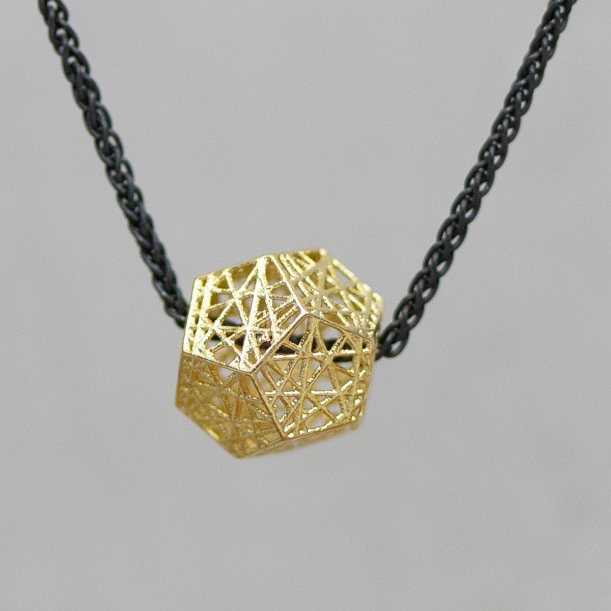 Collier gemaakt van 925 geoxideerd sterling zilver aan het collier zit een 3D hanger gemaakt van 14 karaat goud. De vorm van de hanger doet ons denken aan voetbal. De glans van 925 sterling zilver maakt het een gewild edelmetaal voor de vervaardiging van sieraden. Het bestaat uit 92,5% puur zilver en 7,5% koper. Puur zilver is een zacht en buigzaam materiaal, het koper in 925 sterling zilver zorgt voor de stevigheid. De sieraden van Jeh Jewels zijn nikkel vrij. Op dit sieraad is gebruik gemaakt van geoxideerd zilver, dit is een oppervlakte bewerking. Het is mogelijk dat de geoxideerde laag na verloop van tijd door slijtage gaat vervagen. De gouden sieradenlijn van Jéh is gemaakt van 14 karaats goud. Dit karaatgehalte wordt in Nederland het meest gebruikt, vanwege de hardheid en de kleur. Puur goud is te zacht om draagbare sieraden van te maken, daarom worden er bij metalen gebruikt. Vaak wordt er zilver en koper gebruikt zodat je kunt blijven spreken van 'edele metalen'. Bij 14 karaat goud zijn er van de 1000 delen, 585 delen puur goud. De overige 415 delen bestaan dus uit de overige metalen.