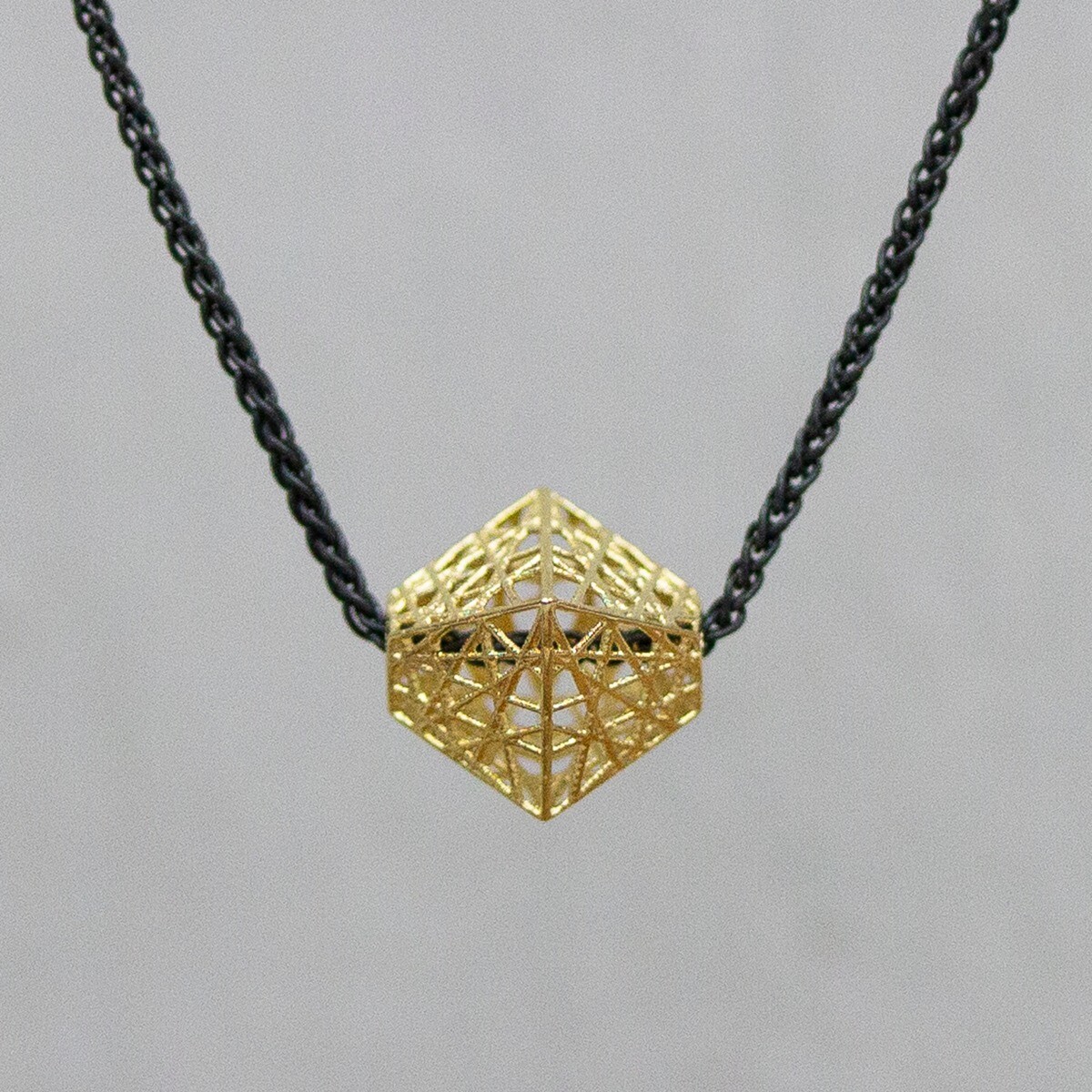 Collier gemaakt van 925 geoxideerd sterling zilver aan het collier zit een hanger van 14 karaat goud. De 3D hanger heeft de vorm van een bipiramide. De glans van 925 sterling zilver maakt het een gewild edelmetaal voor de vervaardiging van sieraden. Het bestaat uit 92,5% puur zilver en 7,5% koper. Puur zilver is een zacht en buigzaam materiaal, het koper in 925 sterling zilver zorgt voor de stevigheid. De sieraden van Jeh Jewels zijn nikkel vrij. Op dit sieraad is gebruik gemaakt van geoxideerd zilver, dit is een oppervlakte bewerking. Het is mogelijk dat de geoxideerde laag na verloop van tijd door slijtage gaat vervagen. De gouden sieradenlijn van Jéh is gemaakt van 14 karaats goud. Dit karaatgehalte wordt in Nederland het meest gebruikt, vanwege de hardheid en de kleur. Puur goud is te zacht om draagbare sieraden van te maken, daarom worden er bij metalen gebruikt. Vaak wordt er zilver en koper gebruikt zodat je kunt blijven spreken van 'edele metalen'. Bij 14 karaat goud zijn er van de 1000 delen, 585 delen puur goud. De overige 415 delen bestaan dus uit de overige metalen.