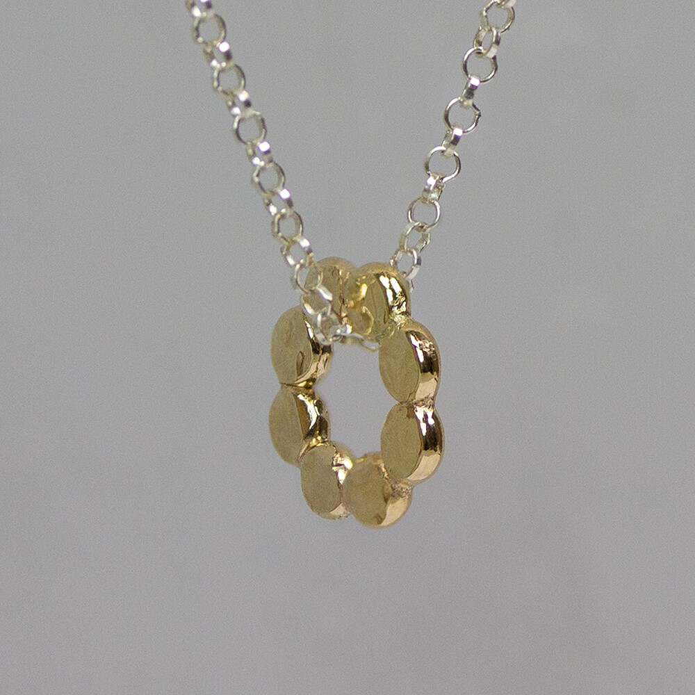 Collier gemaakt van 925 sterling zilver met daaraan een bloem gemaakt van Goldfilled. De bloem is niet egaal, maar is bewerkt met een handmade hamerslag.