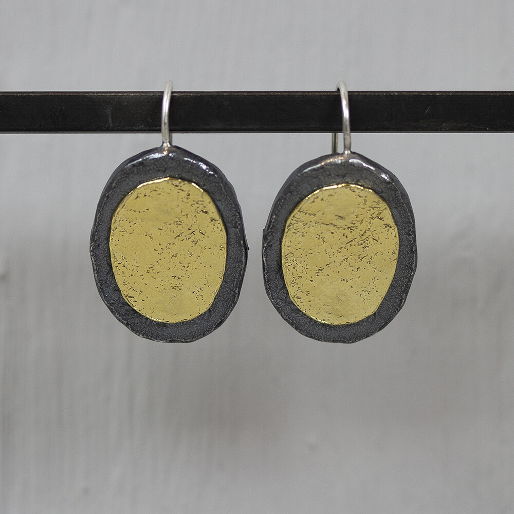 Oorhanger gemaakt van 925 sterling zilver, geoxideerd zilver en zilver verguld in een ovale vorm. De glans van 925 sterling zilver maakt het een gewild edelmetaal voor de vervaardiging van sieraden. Het bestaat uit 92,5% puur zilver en 7,5% koper. Puur zilver is een zacht en buigzaam materiaal, het koper in 925 sterling zilver zorgt voor de stevigheid. De sieraden van Jeh Jewels zijn nikkel vrij. Op dit sieraad is gebruik gemaakt van geoxideerd zilver, dit is een oppervlakte bewerking. Het is mogelijk dat de geoxideerde laag na verloop van tijd door slijtage gaat vervagen. Vergulden is het bedekken van een voorwerp met een laagje goud. Dit artikel is door een goudbad gehaald wat ervoor zorgt dat het zilver volledig bedekt wordt met een laagje goud. Resultaat een mooie glanzende afwerking met een laagje echt goud wat ook wel silverplated of goldplated wordt genoemd.