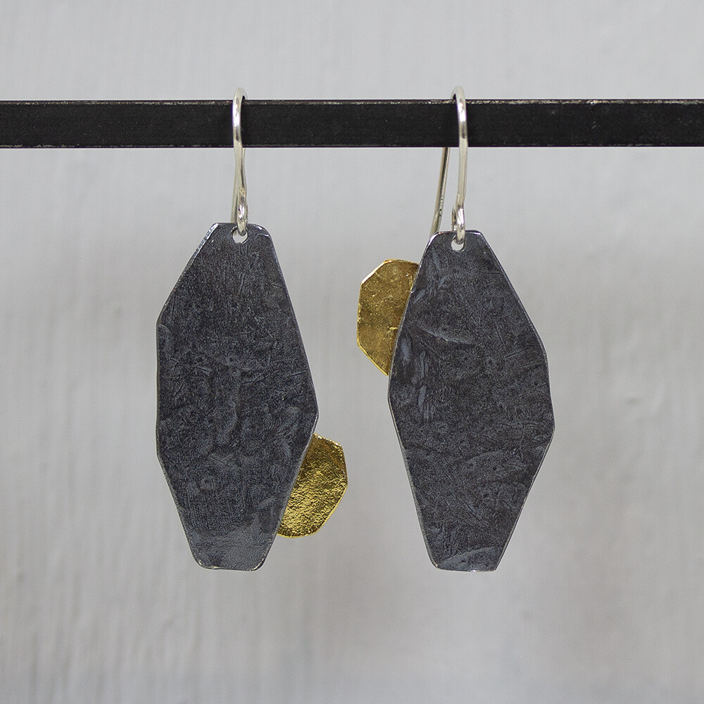 Oorhangers gemaakt van 925 sterling zilver, met geoxideerd zilver en zilver verguld. Deze oorbellen zijn net een beetje anders en toch zijn ze een paar. De glans van 925 sterling zilver maakt het een gewild edelmetaal voor de vervaardiging van sieraden. Het bestaat uit 92,5% puur zilver en 7,5% koper. Puur zilver is een zacht en buigzaam materiaal, het koper in 925 sterling zilver zorgt voor de stevigheid. De sieraden van Jeh Jewels zijn nikkel vrij. Op dit sieraad is gebruik gemaakt van geoxideerd zilver, dit is een oppervlakte bewerking. Het is mogelijk dat de geoxideerde laag na verloop van tijd door slijtage gaat vervagen. Vergulden is het bedekken van een voorwerp met een laagje goud. Dit artikel is door een goudbad gehaald wat ervoor zorgt dat het zilver volledig bedekt wordt met een laagje goud. Resultaat een mooie glanzende afwerking met een laagje echt goud wat ook wel silverplated of goldplated wordt genoemd.