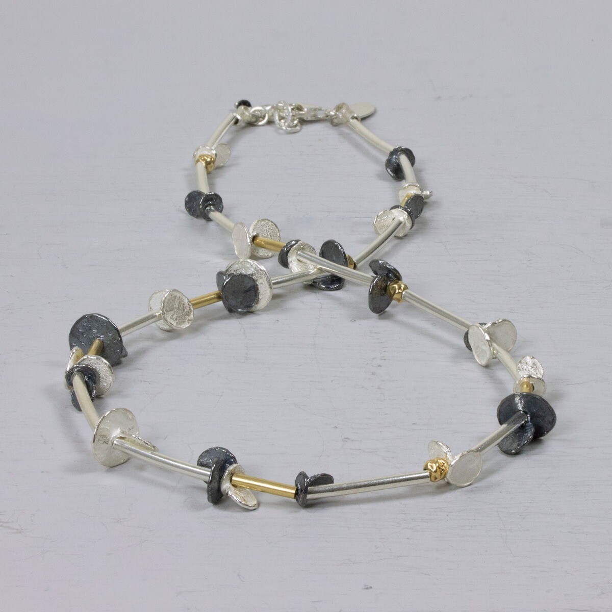 Collier gemaakt van 925 (geoxideerd) sterling zilver in combinatie met Goldfilled. Een zoals wij dat hier noemen "buisjes collier", maar dit collier heeft niet alleen buisje. Het collier heeft ook schijfjes, wat hem lekker speels en vrolijk maakt.