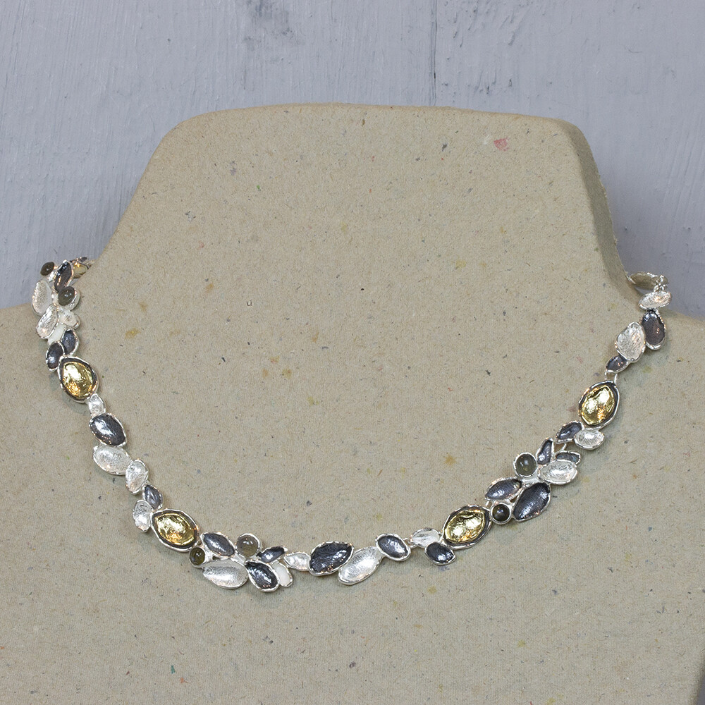 Collier gemaakt van blaadjes van 925 sterling zilver, geoxideerd zilver en zilver verguld met tussen de blaadjes Labradotiet.