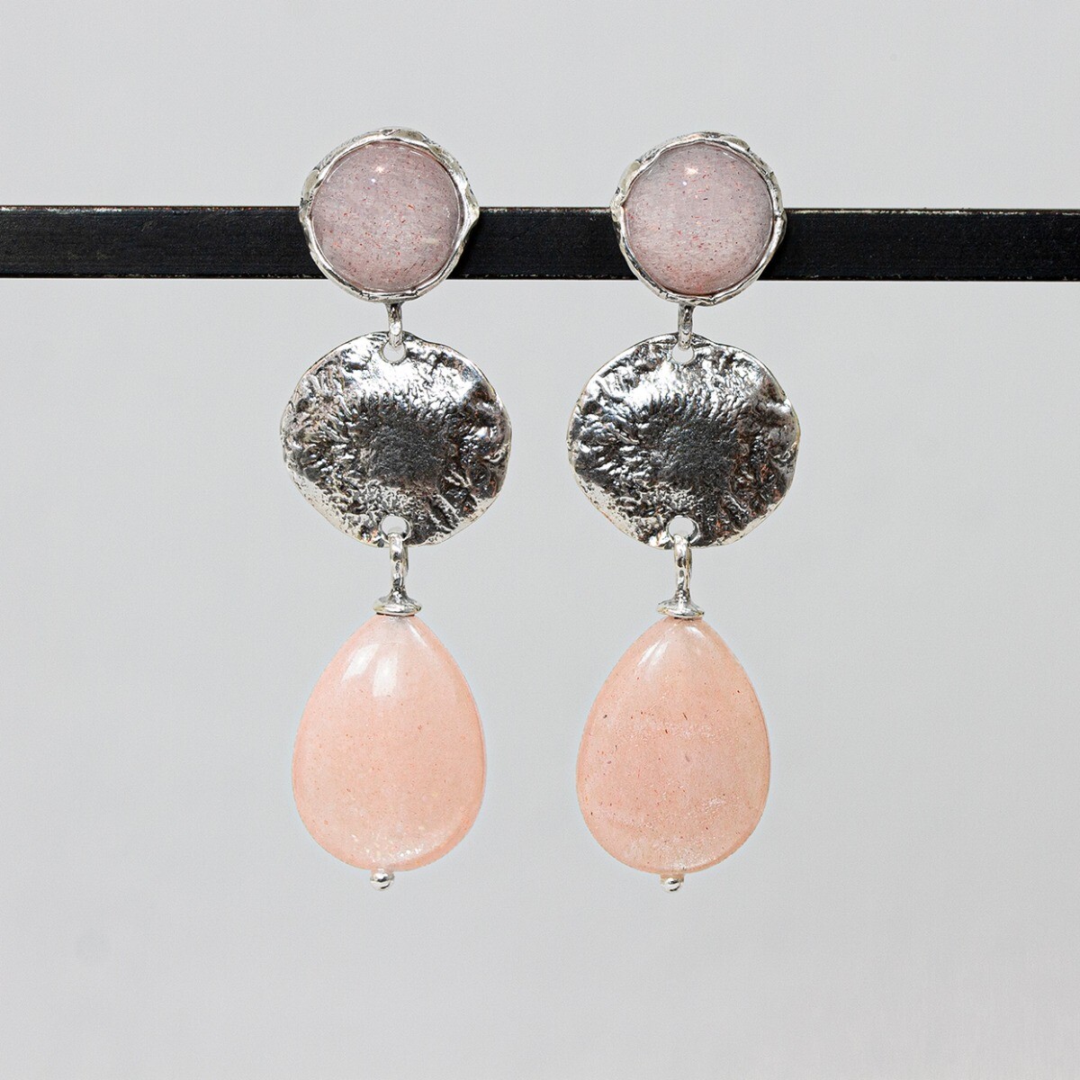 Oorbel van Jeh Jewels gemaakt van geoxideerd glimmend zilver en Roze Maansteen. De Roze Maansteen varieert in kleur van zalmroze tot oranjeroze. Zoals de naam al zegt, staat de steen sterk in contact met de maan. De steen heeft een positief effect op de intuïtie en vruchtbaarheid. Daarnaast heeft het een kalmerende werking op het gevoelsleven.
