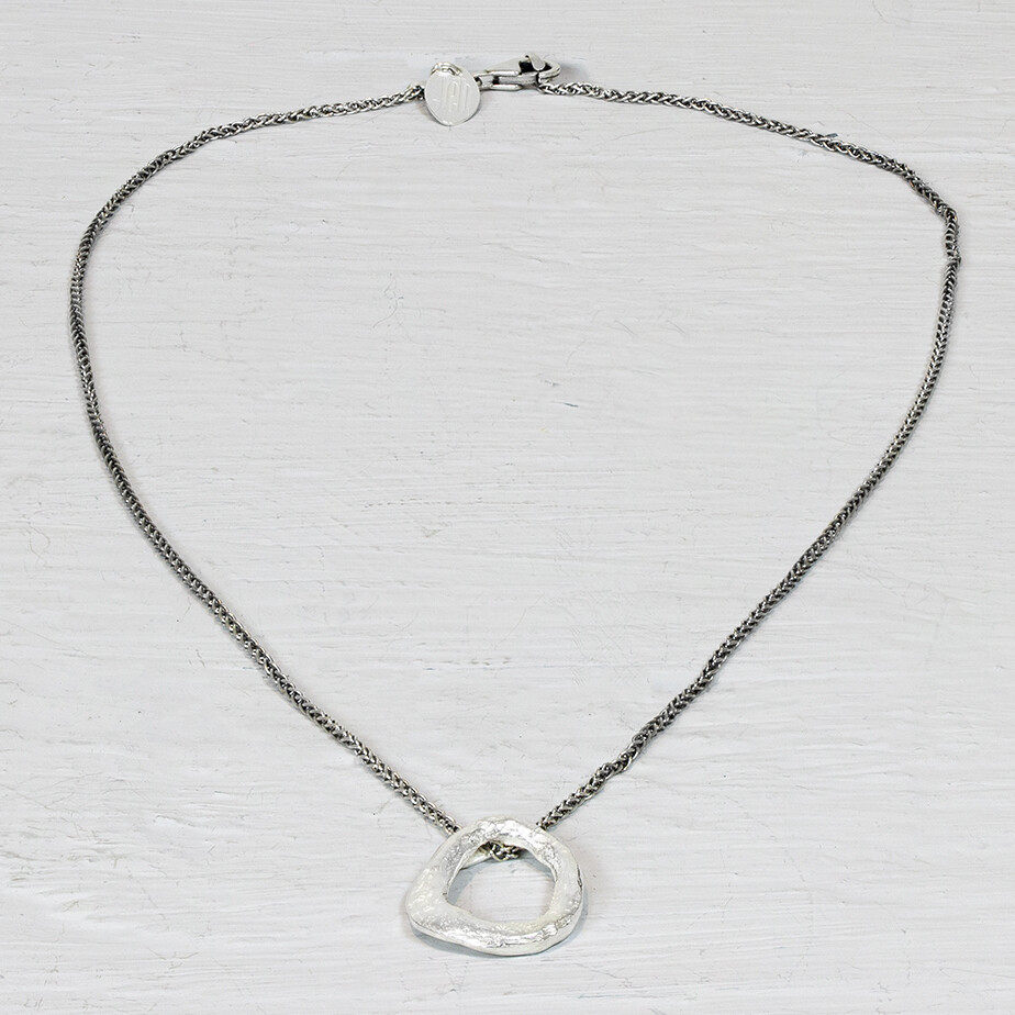 Collier van Jeh Jewels met zilveren cirkel. Dit zilveren collier is uniek in zijn soort. De zilveren cirkel onderin is namelijk net niet helemaal rond. Dit geeft het zijn autentieke karakter en maakt 'm perfect te combineren.