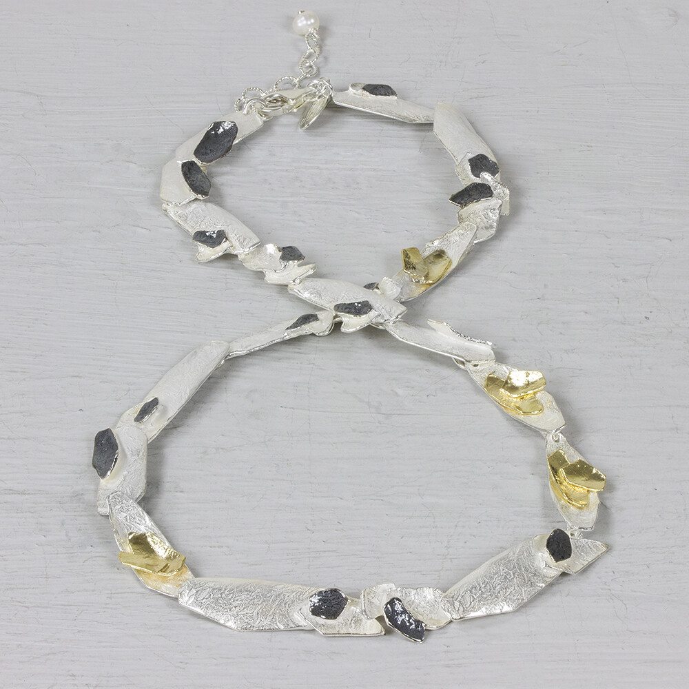 Collier uit de najaarscollectie van Jeh Jewels gemaakt van 925 sterling zilver, geoxideerd zilver en zilver verguld. Dit collier met grove schakels en de drie kenmerkende kleuren, een typisch en echt "Jéh" collier! De glans van 925 sterling zilver maakt het een gewild edelmetaal voor de vervaardiging van sieraden. Het bestaat uit 92,5% puur zilver en 7,5% koper. Puur zilver is een zacht en buigzaam materiaal, het koper in 925 sterling zilver zorgt voor de stevigheid. De sieraden van Jéh Jewels zijn nikkel vrij. Op dit sieraad is gebruik gemaakt van geoxideerd zilver, dit is een oppervlakte bewerking. Het is mogelijk dat de geoxideerde laag na verloop van tijd door slijtage gaat vervagen. Vergulden is het bedekken van een voorwerp met een laagje goud. Dit artikel is door een goudbad gehaald wat ervoor zorgt dat het zilver volledig bedekt wordt met een laagje goud. Resultaat een mooie glanzende afwerking met een laagje echt goud wat ook wel silverplated of goldplated wordt genoemd.