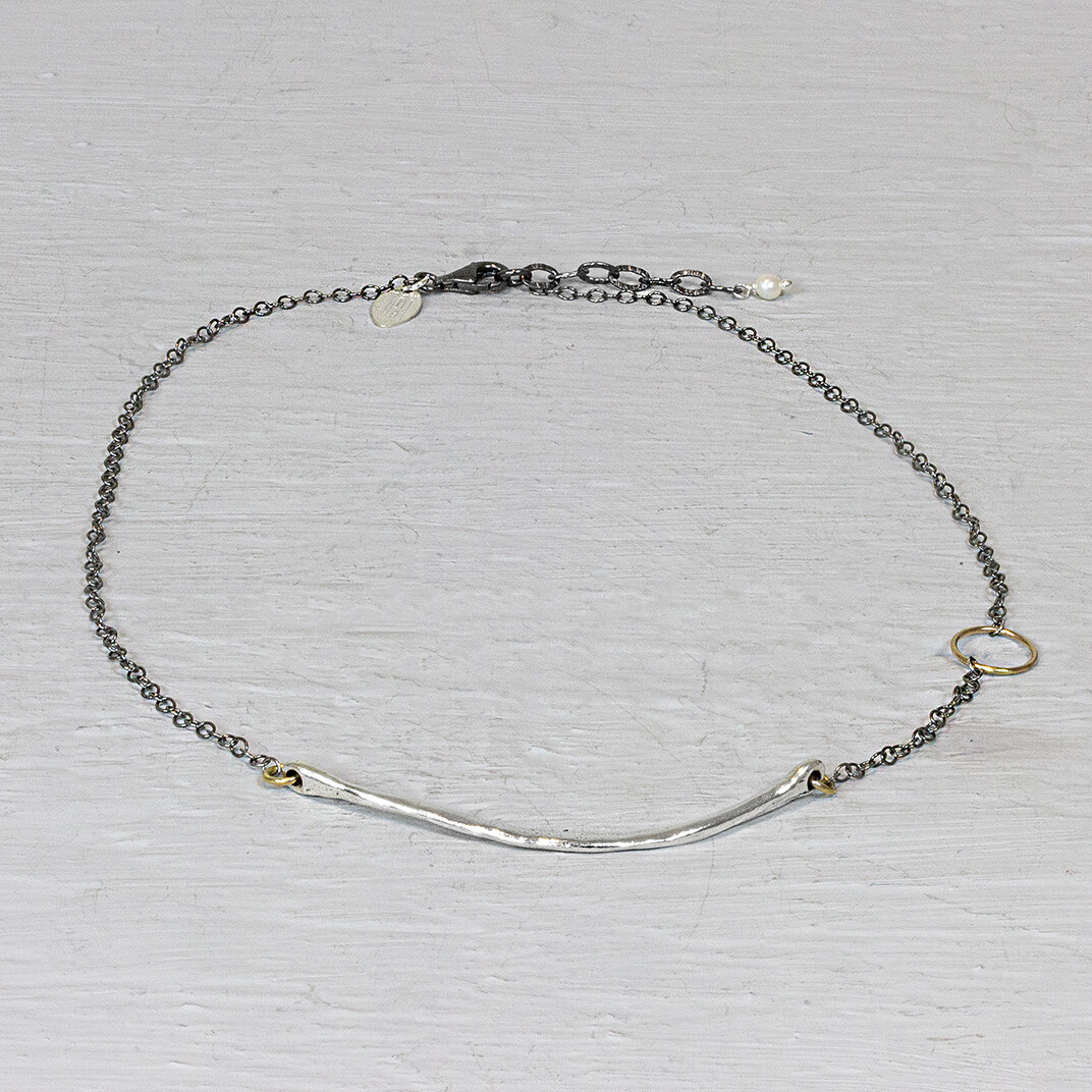 Collier van Jeh Jewels met zilveren glimlach en gouden cirkel. Dit collier tovert een lach op ieders gezicht. Hij heeft namelijk een zilveren halve boog in het midden hangen met daarboven een mooi gouden rondje. Het geoxideerde kettinkje zorgt voor een regenboog aan kleur.