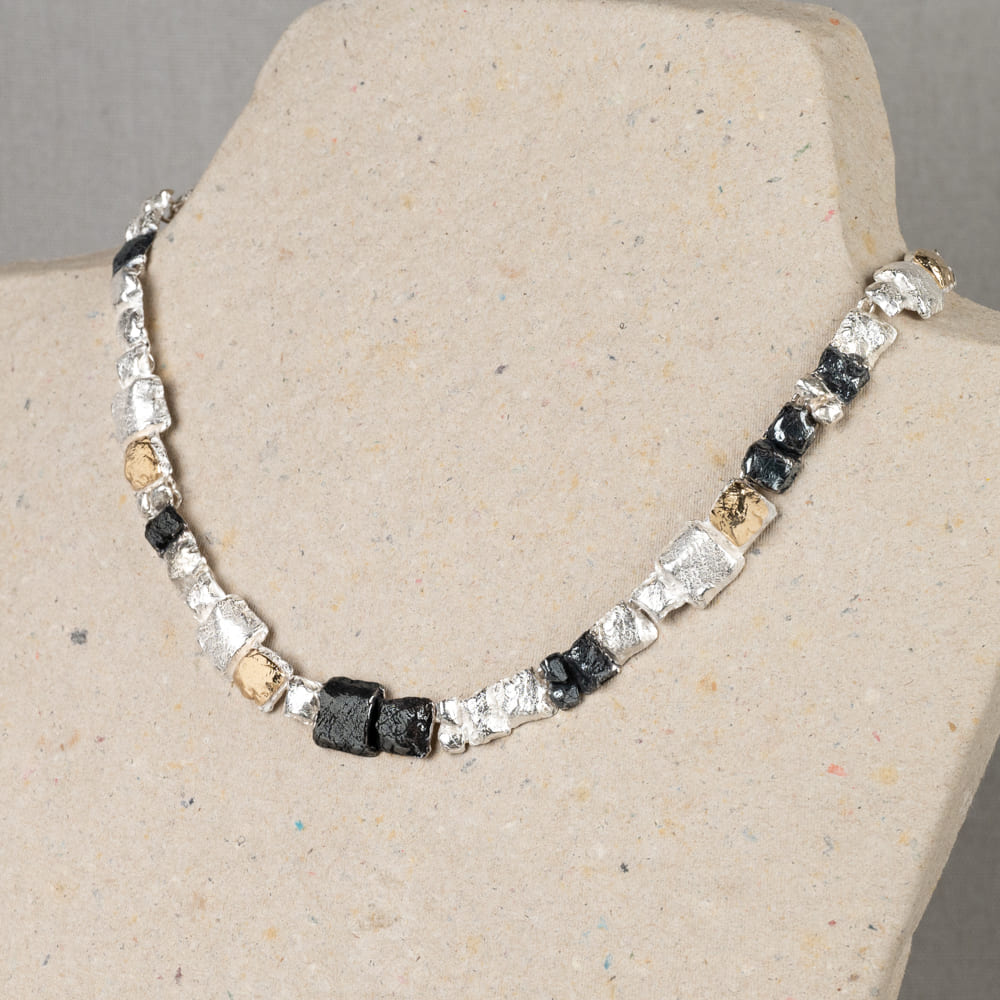 Dit collier is gemaakt van drie soorten zilver. Namelijk 925 sterling zilver, geoxideerd zilver en verguld zilver. Door deze kleurencombinatie is dit collier makkelijk te verwerken in elke soort look.