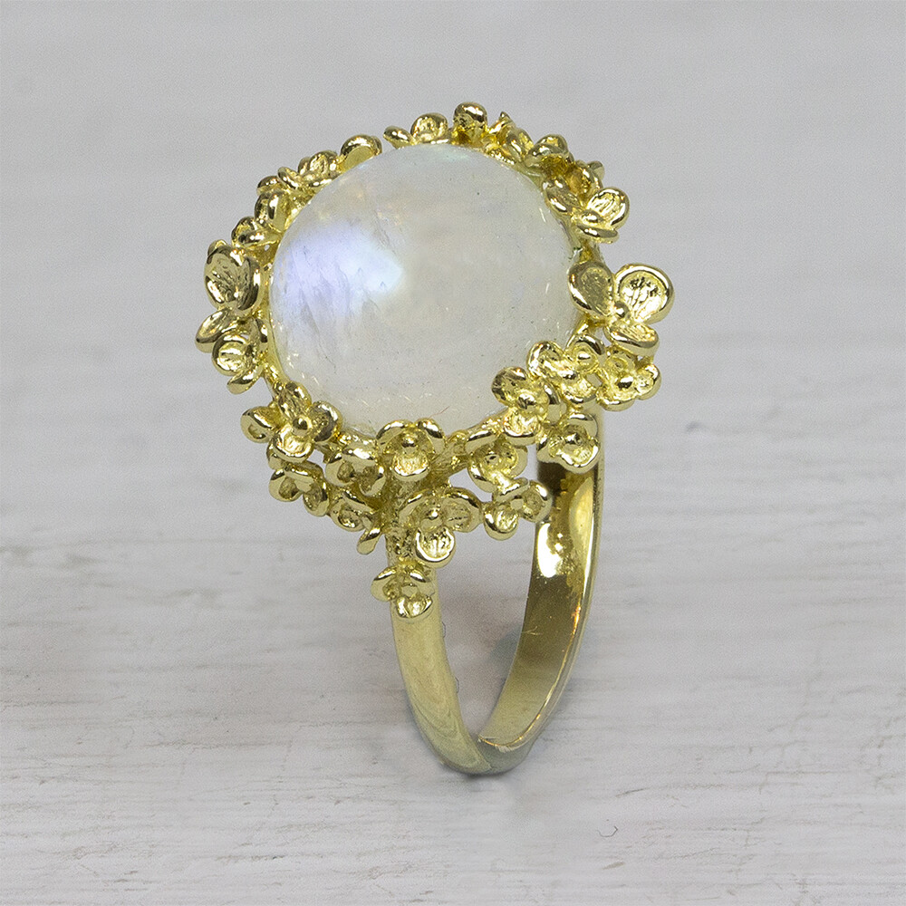 Ring uit de goud-collectie van Jeh Jewels, gemaakt van 14 karaat goud. In de rand van bloesem zit een regenboog Maansteen. Staat de gewenste maat hier niet tussen, stuur ons dan even een berichtje en vraag naar de mogelijkheden. De gouden sieradenlijn van Jéh is gemaakt van 14 karaats goud. Dit karaatgehalte wordt in Nederland het meest gebruikt, vanwege de hardheid en de kleur. Puur goud is te zacht om draagbare sieraden van te maken, daarom worden er bij metalen gebruikt. Vaak wordt er zilver en koper gebruikt zodat je kunt blijven spreken van 'edele metalen'. Bij 14 karaat goud zijn er van de 1000 delen, 585 delen puur goud. De overige 415 delen bestaan dus uit de overige metalen. Prijswijzigingen voorbehouden!