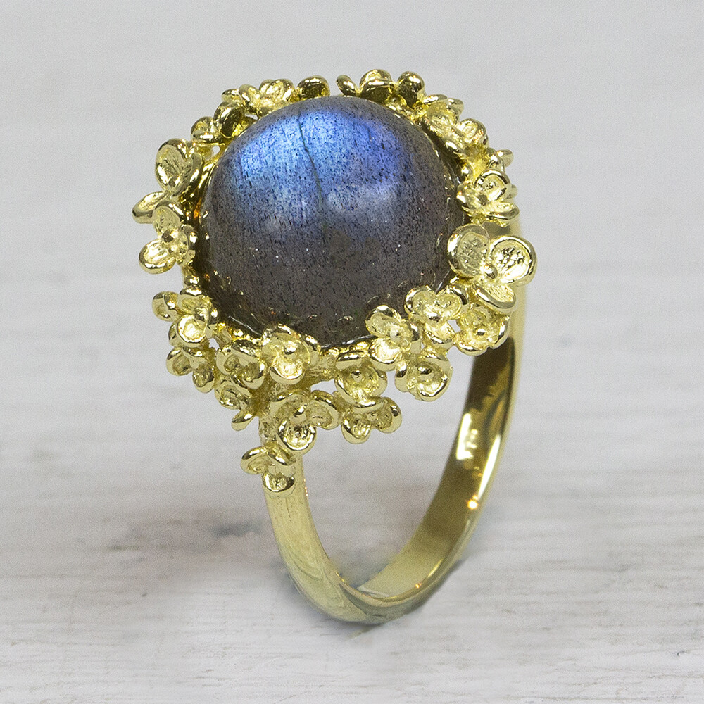 Ring uit de goud-collectie van Jeh Jewels, gemaakt van 14 karaat goud. In de rand van bloesem zit een Labradoriet. Staat de gewenste maat hier niet tussen, stuur ons dan even een berichtje en vraag naar de mogelijkheden. De gouden sieradenlijn van Jéh is gemaakt van 14 karaats goud. Dit karaatgehalte wordt in Nederland het meest gebruikt, vanwege de hardheid en de kleur. Puur goud is te zacht om draagbare sieraden van te maken, daarom worden er bij metalen gebruikt. Vaak wordt er zilver en koper gebruikt zodat je kunt blijven spreken van 'edele metalen'. Bij 14 karaat goud zijn er van de 1000 delen, 585 delen puur goud. De overige 415 delen bestaan dus uit de overige metalen. Prijswijzigingen voorbehouden!