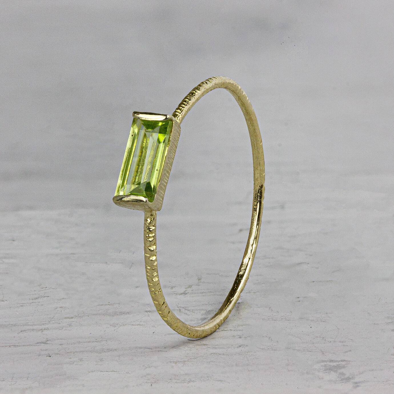 Ring van de N.O.O.R. collectie van Jeh Jewels. Deze ring is gemaakt van 14 karaat goud met een rechthoekige Peridot steen. Deze ring is perfect om te combineren met andere ringen van de N.O.O.R. collectie of om los te dragen. Met welke ring zou jij deze combineren?