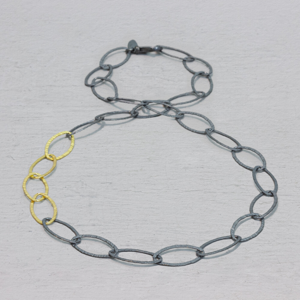Collier navette met schakels die grotendeels van 925 geoxideerd sterling zilver gemaakt zijn en er zijn 4 schakels gemaakt van zilver verguld. Dit collier is perfect te combineren met een armband, ring en oorsieraden van Jéh Jewels.