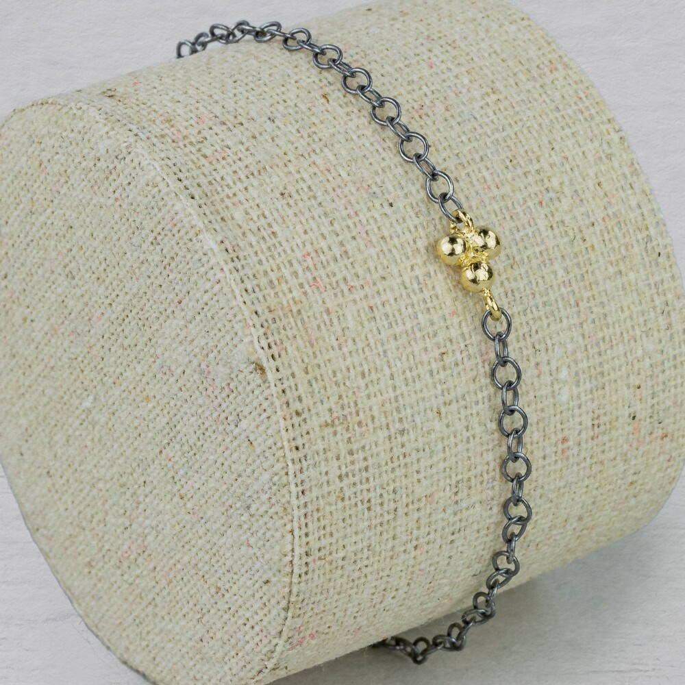 Armband gemaakt van 925 geoxideerd sterling zilver met daaraan een trosje van 9 karaat. Combineer met het bijpassende collier. De armband is verstelbaar waardoor je hem ook op een andere lengte kunt dragen.