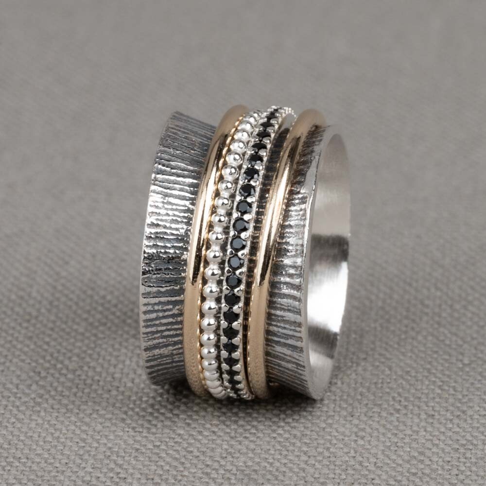 Ring gemaakt van 925 sterling zilver, met daaromheen ringen van Goldfilled, geoxideerd zilver en zirkonia's. Deze ring met een breedte van 1,5 cm loopt rond aan de binnenkant waardoor hij heel lekker zit.