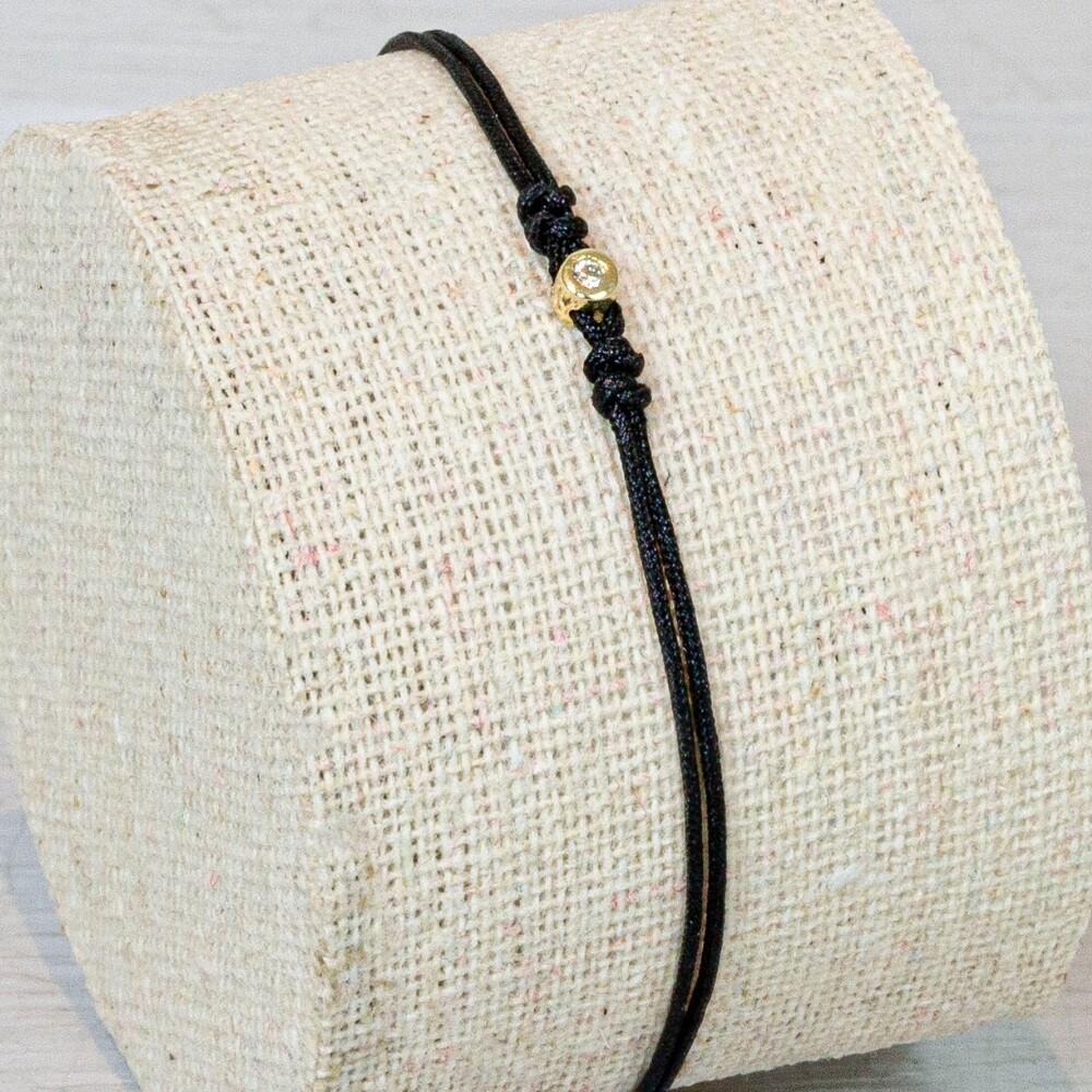 Armband koord met in het miden een knopje gemaakt van 14 karaat goud met daarin een Diamant. Deze armband is verstelbaar!