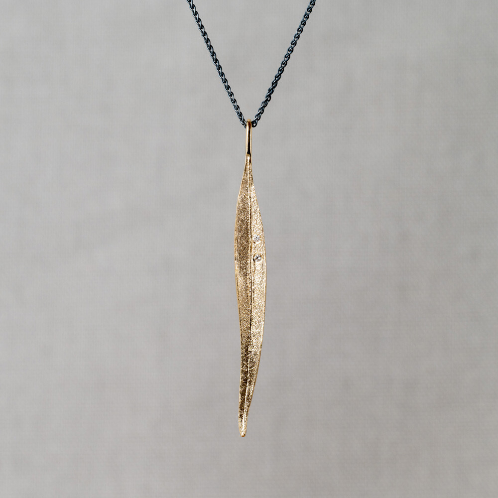 Collier gemaakt van geoxideerd zilver in combinatie met een 14 karaat hanger in de vorm van een blad met daarin 2 diamanten. Combineer met de bijpassende oorbellen!