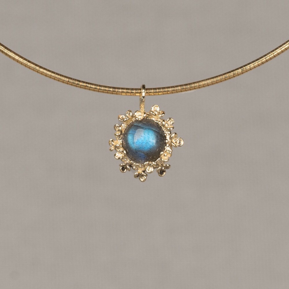 Hanger gemaakt van 14 karaat goud in combinatie met de edelsteen Labradoriet. Labradoriet is een magische, beschermende en spirituele steen. Lees alles over deze edelsteen via onderstaande button. Combineer deze hanger met de andere gouden sieraden uit de Blossom-lijn!