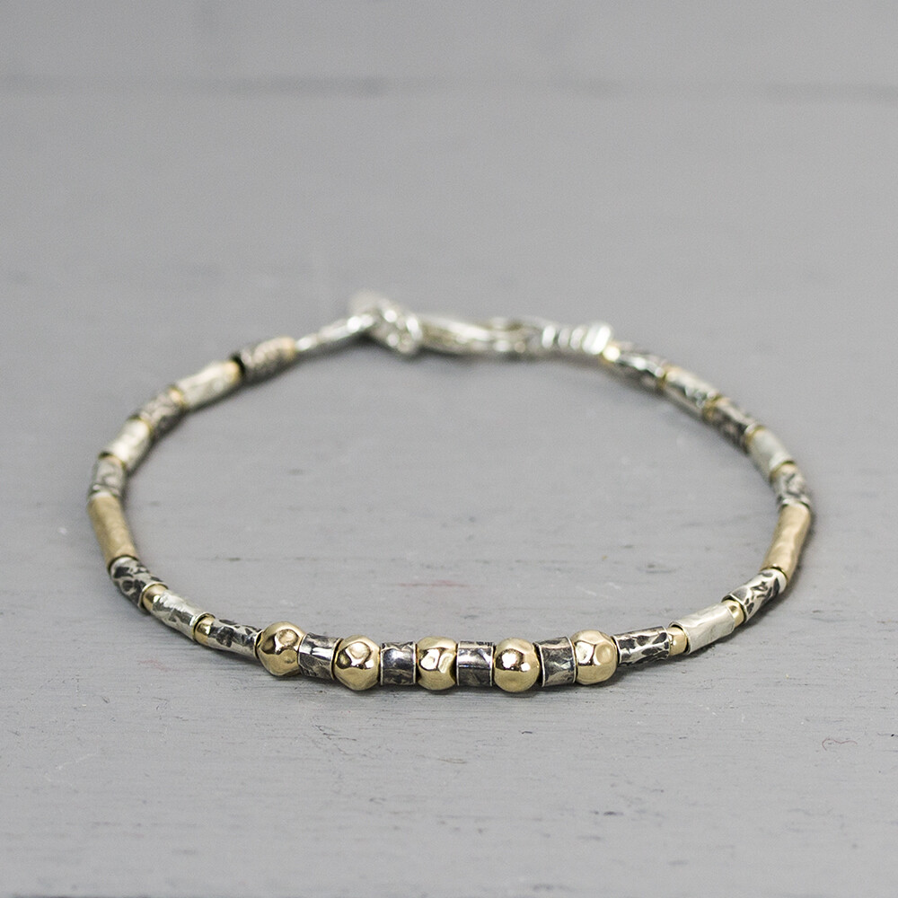 Een nieuwe armband in de serie wat wij 'buisjes" armbanden noemen. Deze armband is gemaakt van 925 sterling zilver, geoxideerd zilver en Goldfilled. De glans van 925 sterling zilver maakt het een gewild edelmetaal voor de vervaardiging van sieraden. Het bestaat uit 92,5% puur zilver en 7,5% koper. Puur zilver is een zacht en buigzaam materiaal, het koper in 925 sterling zilver zorgt voor de stevigheid. De sieraden van Jeh Jewels zijn nikkel vrij. Op dit sieraad is gebruik gemaakt van geoxideerd zilver, dit is een oppervlakte bewerking. Het is mogelijk dat de geoxideerde laag na verloop van tijd door slijtage vervaagd. Goldfilled komt uit Amerika en wordt daar al langer gebruikt voor de vervaardiging van sieraden met een "touch of gold" voor een betaalbare prijs. Het goldfilled blijft op kleur, is slijtvast en de goudlaag is dik genoeg om lang te kunnen genieten van de warme uitstraling van goud. Goldfilled wordt veelal ook goed verdragen door mensen die allergisch zijn voor andere metalen dan goud.