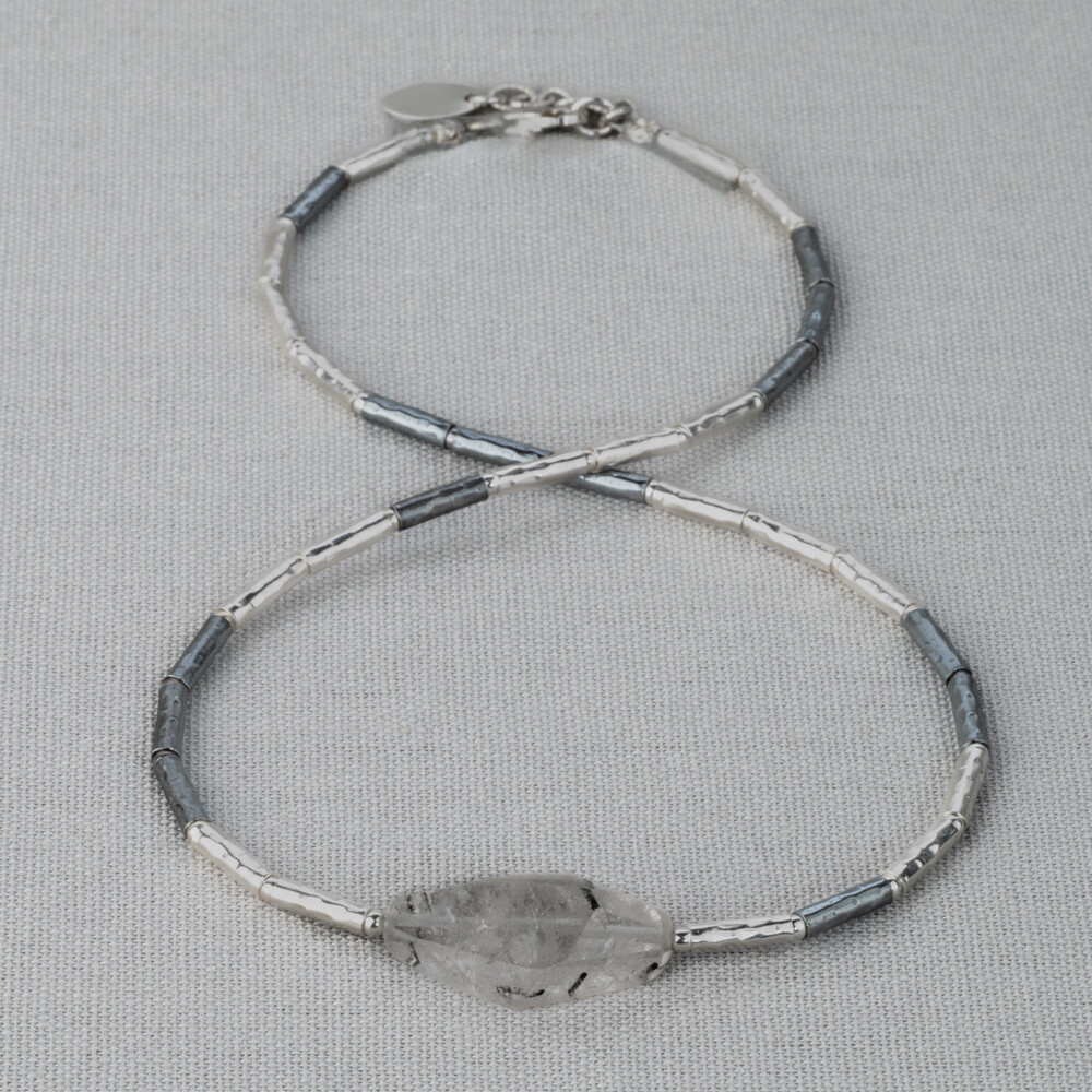 Collier gemaakt van 925 (geoxideerd) sterling zilveren buisjes. In het midden zit de edelsteen Rutielkwarts. Rutielkwarts is een opbeurende en kalmerende steen. Lees alles over deze edelsteen via onderstaande button! Combineer dit collier met een mooie armband, een ring en oorsieraden!